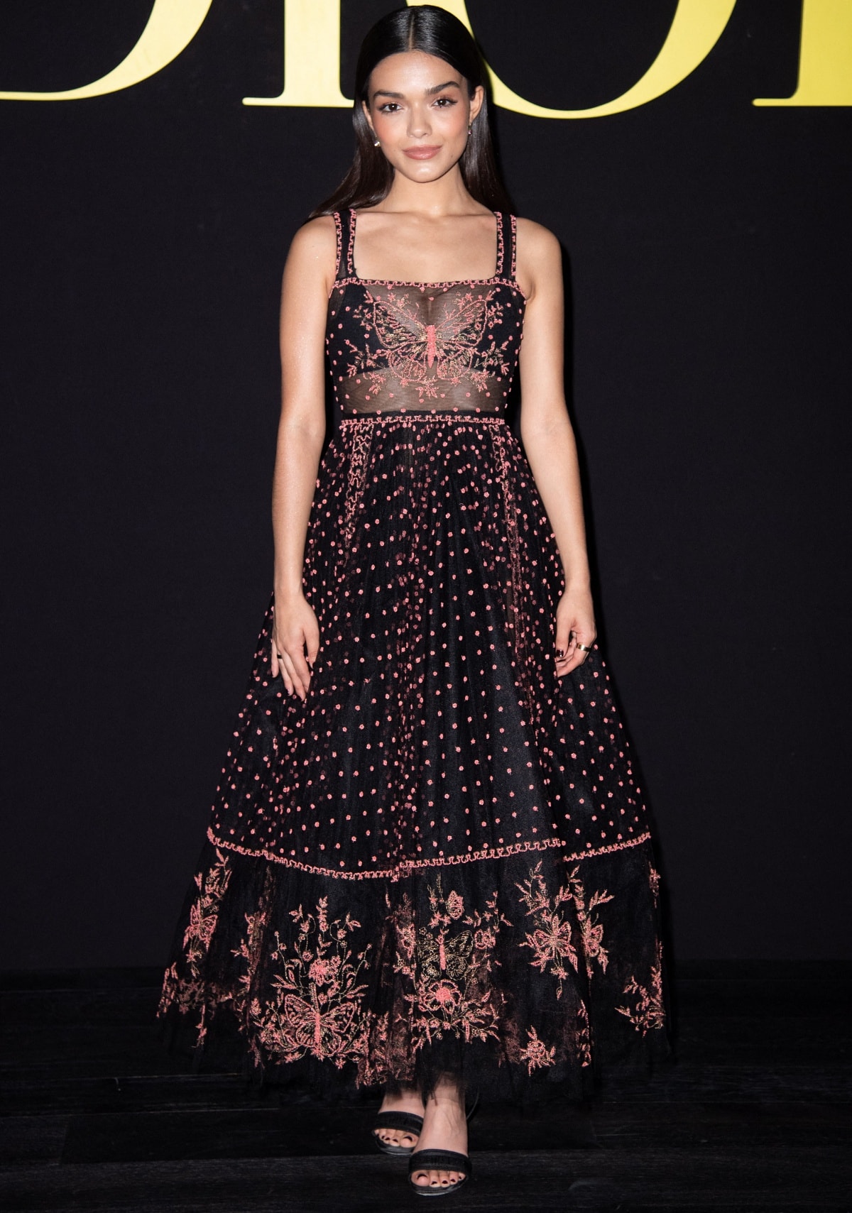 Rachel Zegler exudes modern Dior elegance in a black-and-pink butterfly-embroidered gown and strappy sandals at the brand’s Spring/Summer 2024 show during Paris Fashion Week on September 26, 2023