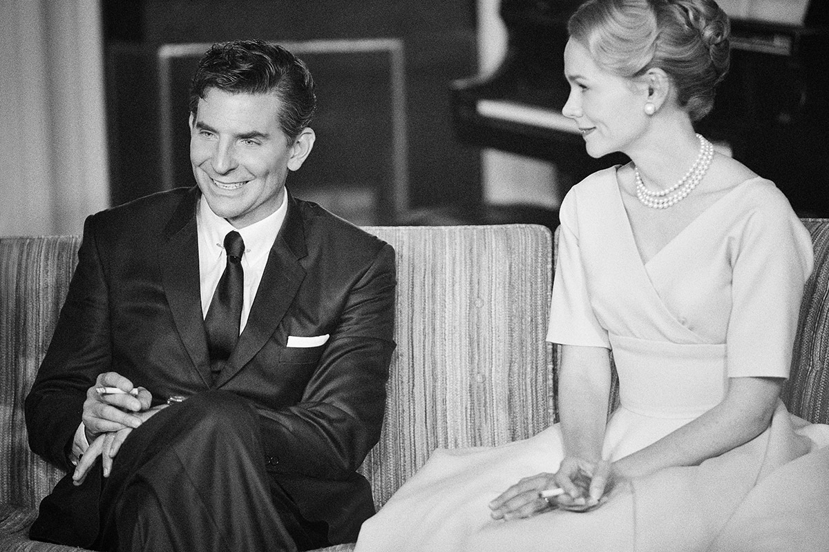 Bradley Cooper and Carey Mulligan exude mid-century sophistication in Maestro, with Cooper in a sharp black suit and skinny tie and Mulligan in a structured wrap dress accented by classic pearls and an elegant updo