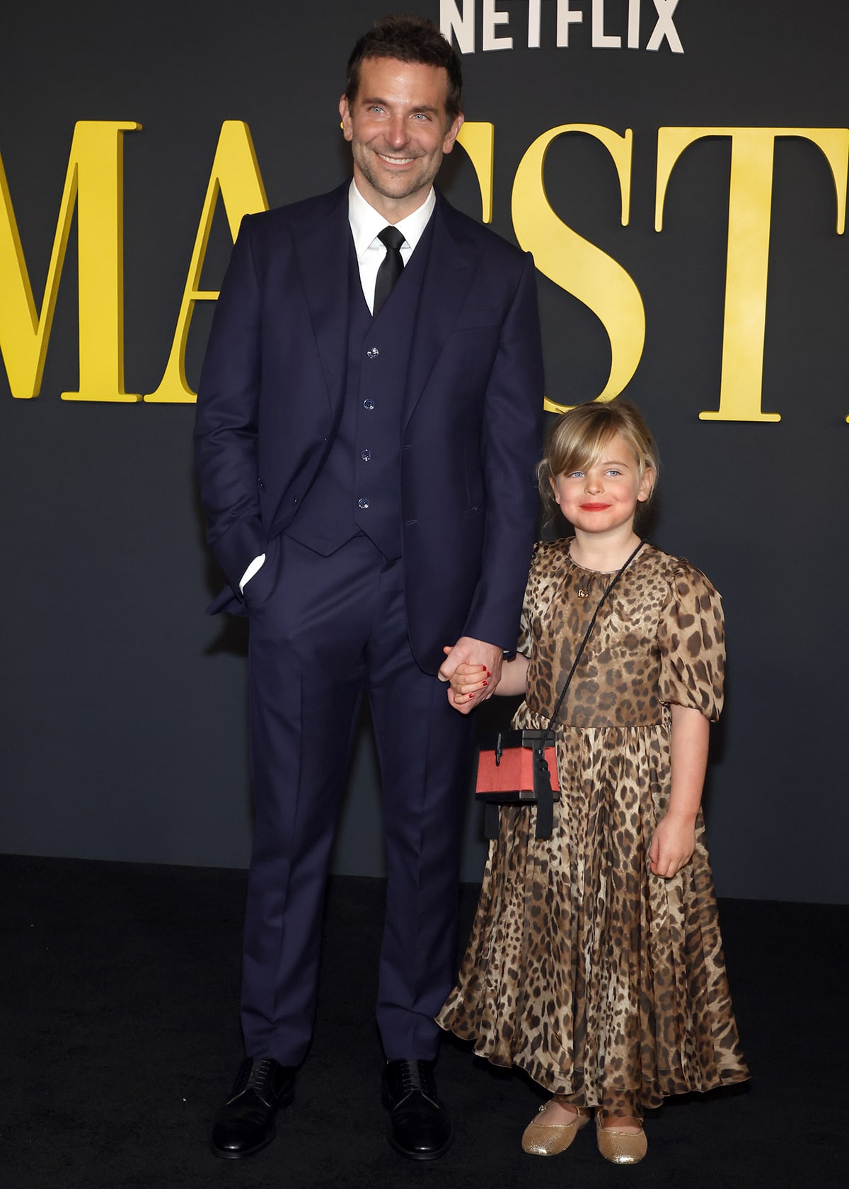 Bradley Cooper holds hands with daughter Lea De Seine, who's clad in a leopard-print Dolce Gabbana dress