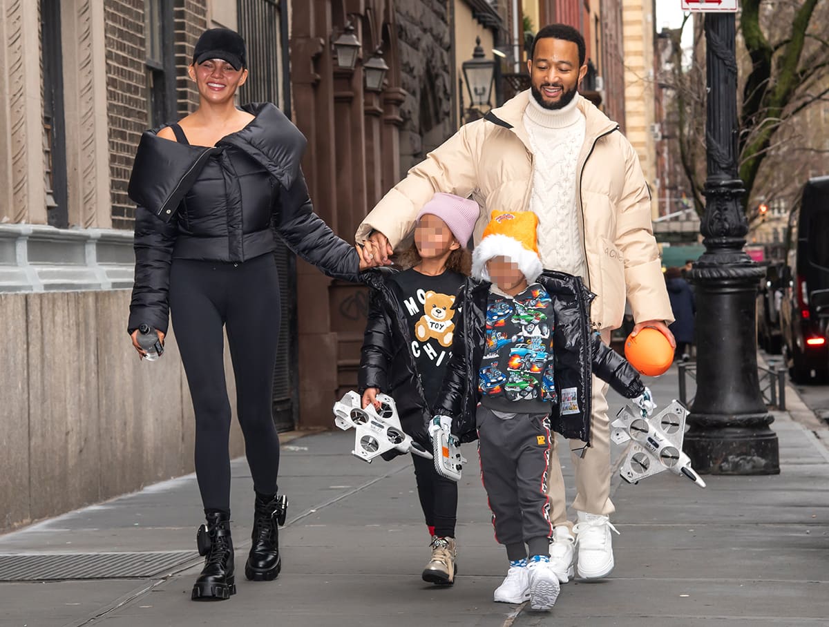 John Legend looks handsome in a beige puffer jacket, off-white cable-knit sweater, and khaki pants, while their kids, Luna and Miles, don matching black puffer jackets