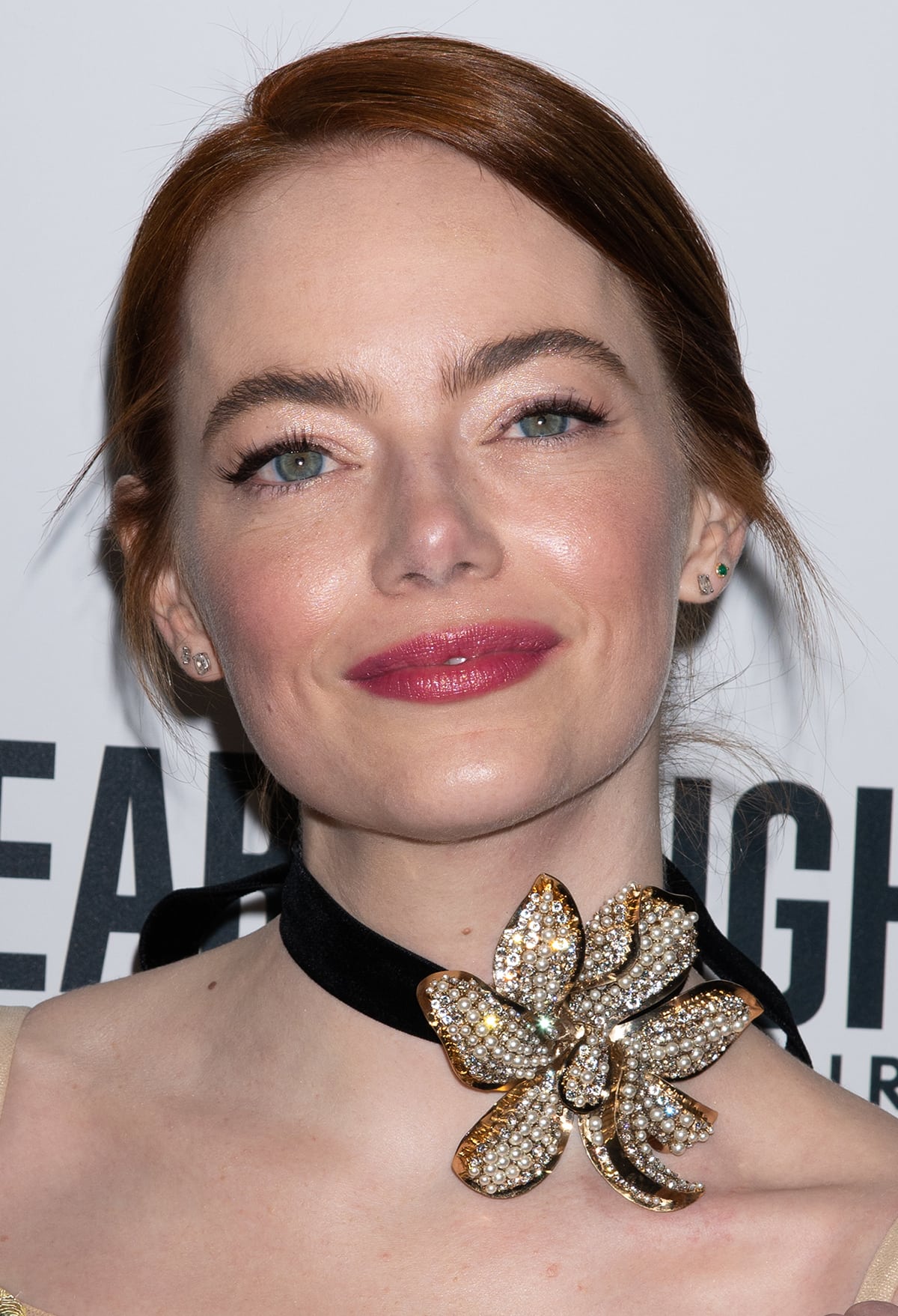Emma Stone highlights her green eyes with mascara and wears pink lipstick and blush by Pat McGrath