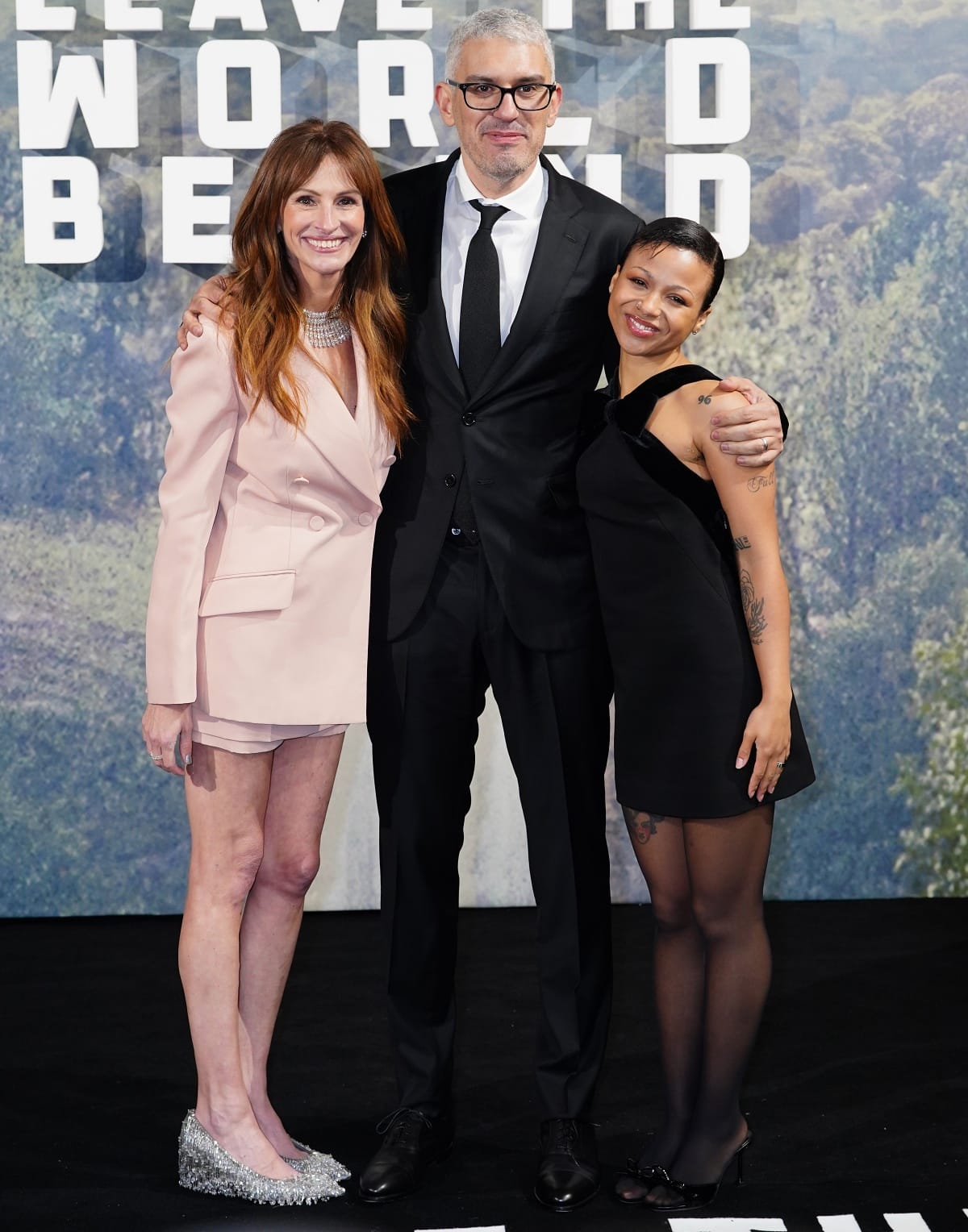 Julia Roberts radiates elegance in a powder-pink Gucci blazer-and-shorts set paired with shimmering beaded Gucci pumps, posing alongside director Sam Esmail and co-star Myha’la Herrold at the Leave the World Behind London screening