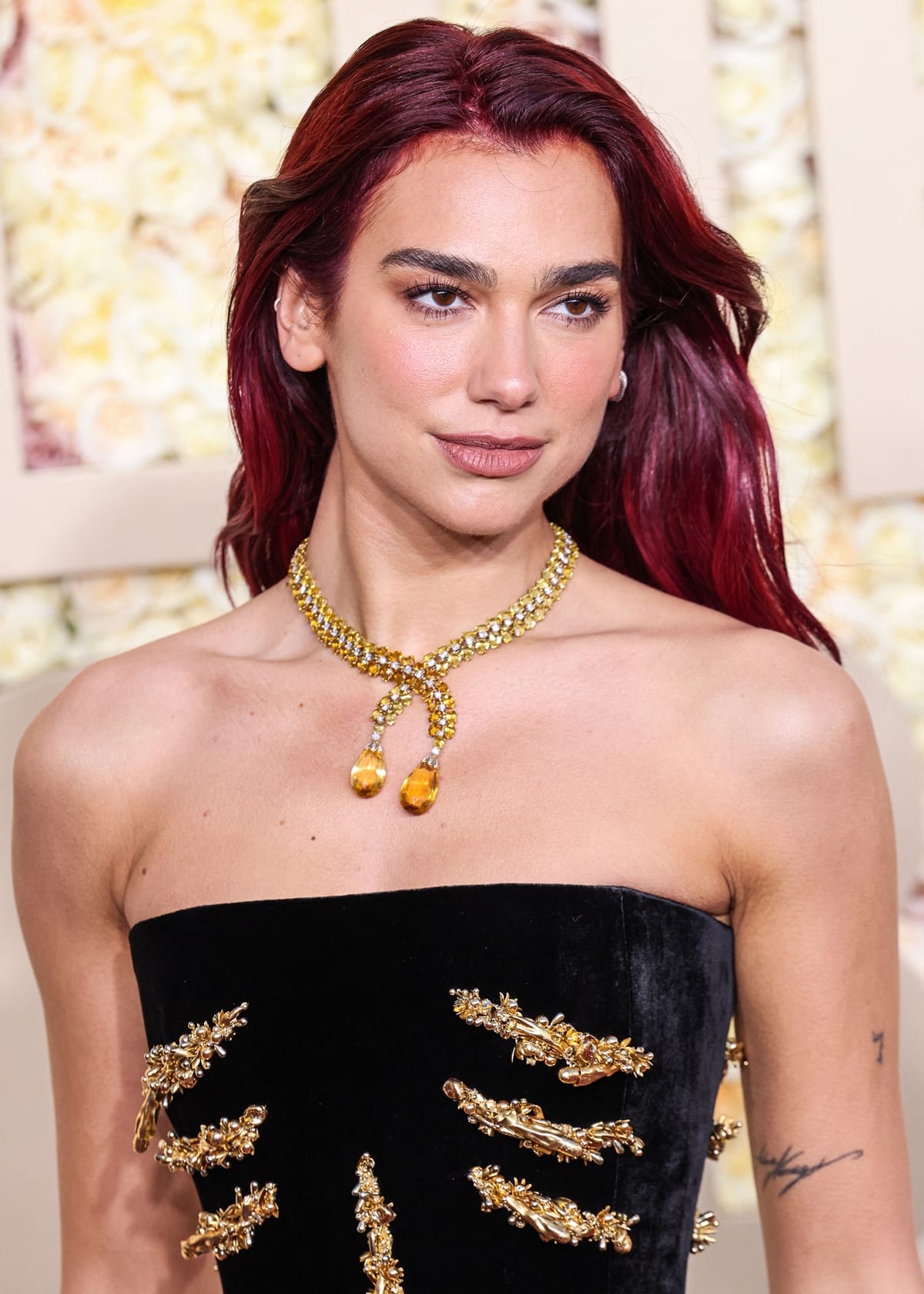 Complementing her Schiaparelli gown, Dua Lipa chose a vintage Tiffany Co. necklace and a ring featuring a large yellow sapphire, adding a touch of timeless glamour to her ensemble