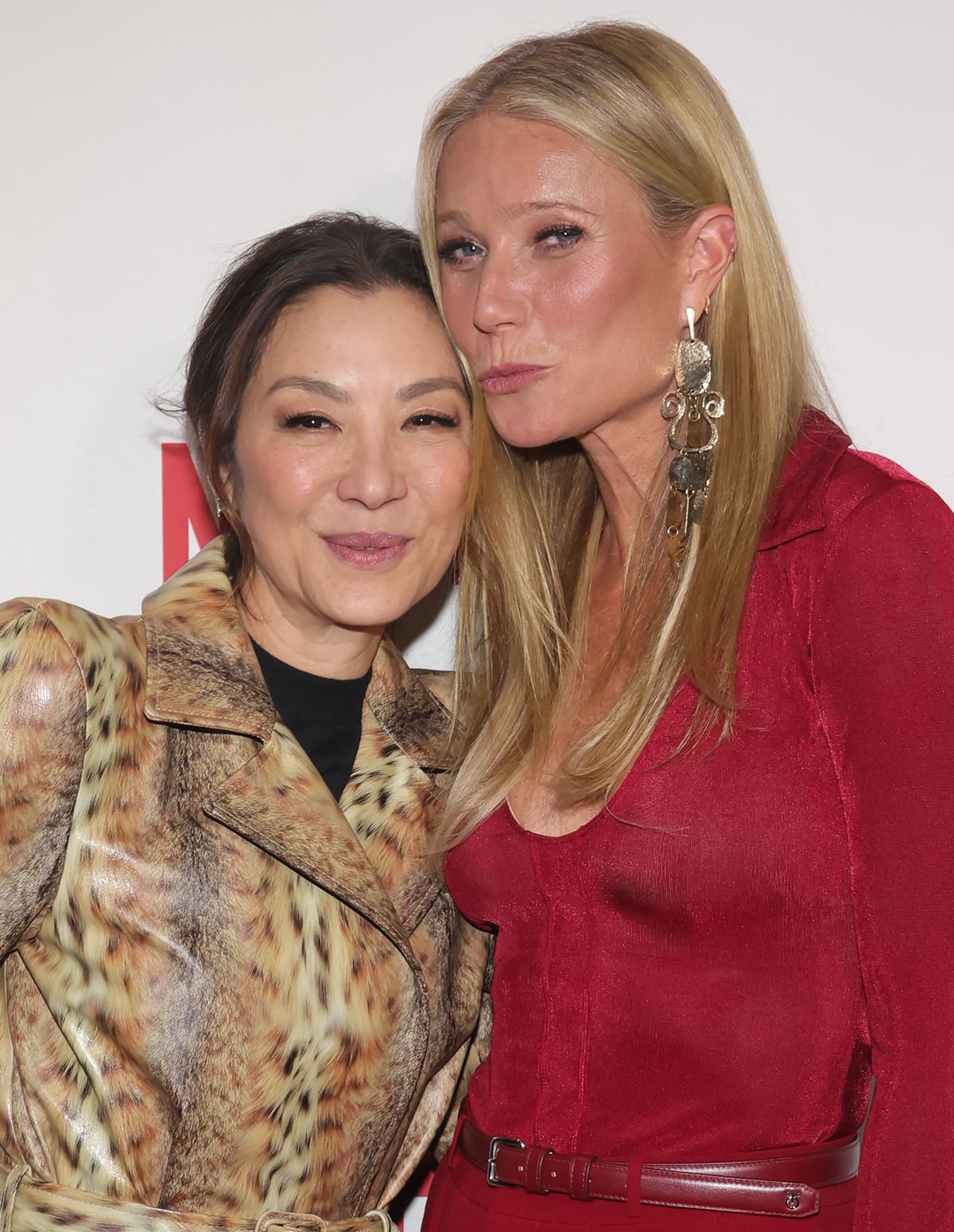 Michelle Yeoh and Gwyneth Paltrow light up the premiere of Netflix's 'The Brothers Sun' with their distinct styles: Yeoh in a daring Balenciaga leopard print trench coat and Paltrow in a stunning red Cong Tri dress, together embodying the glamour of Hollywood's finest