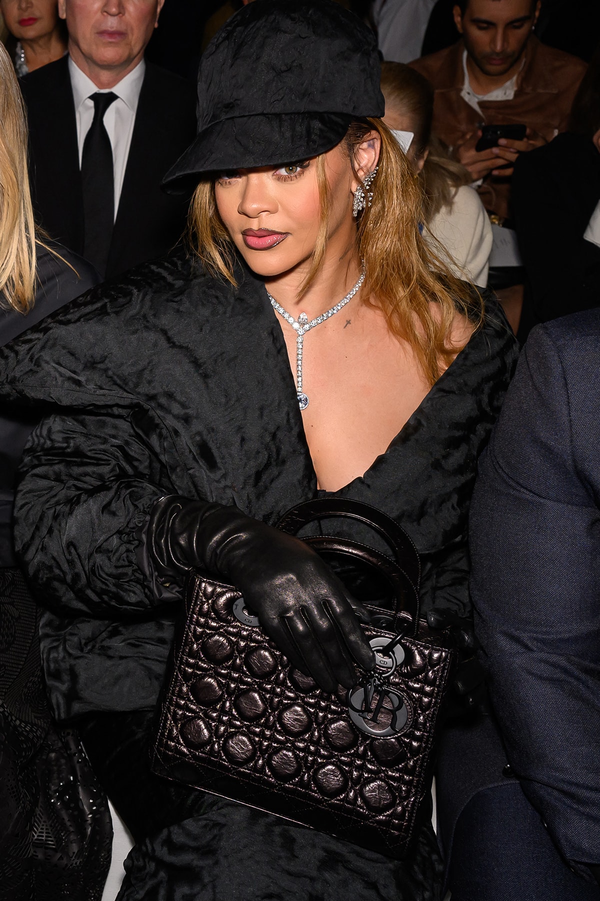 Rihanna gives her ladylike look a tomboy spin with a floppy baseball cap and edgy black leather gloves