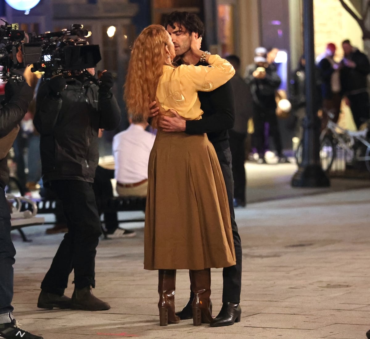 Blake Lively, in a buttercup yellow shirt and brown tea-length skirt paired with glossy heeled boots, shares a steamy moment with Justin Baldoni while filming a dramatic scene for It Ends With Us