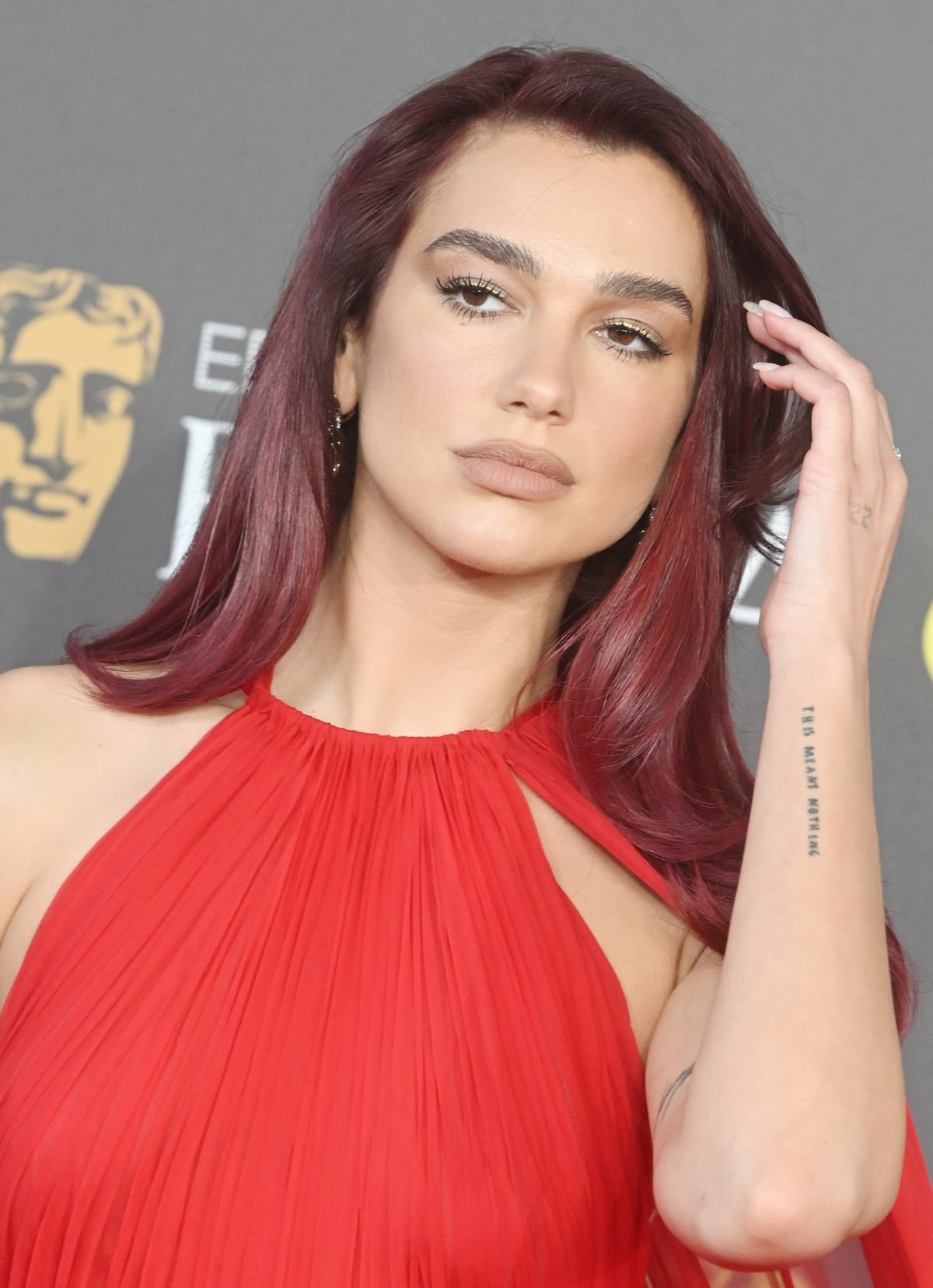 At the peak of the 2024 award season, Dua Lipa embraced the all-red outfit trend with her timeless red ensemble and vibrant cherry-red hair