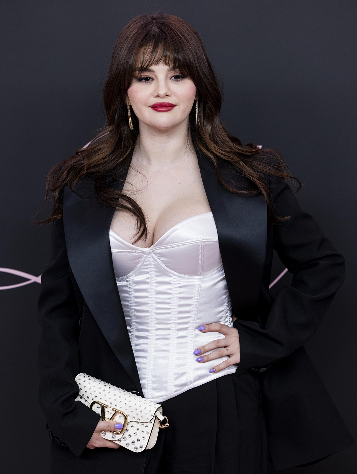 Selena Gomez accessorizes with Jennifer Meyer two-tiered tennis stud dangling earrings and a white studded Valentino clutch