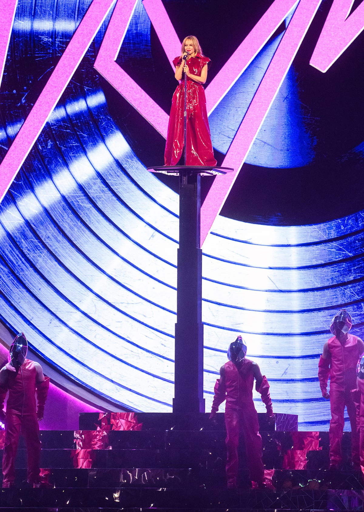Kylie Minogue performs Padam Padam in a red latex trench coat by Dolce Gabbana on the Brit Awards stage