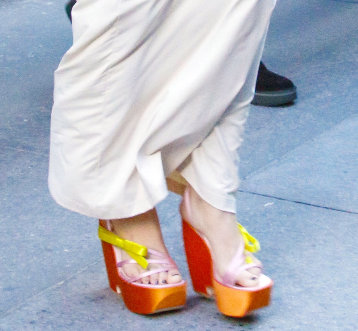 Millie Bobby Brown adds a playful ’90s-inspired twist to her white mermaid skirt with towering Roger Vivier colorblock platform sandals in neon satin hues