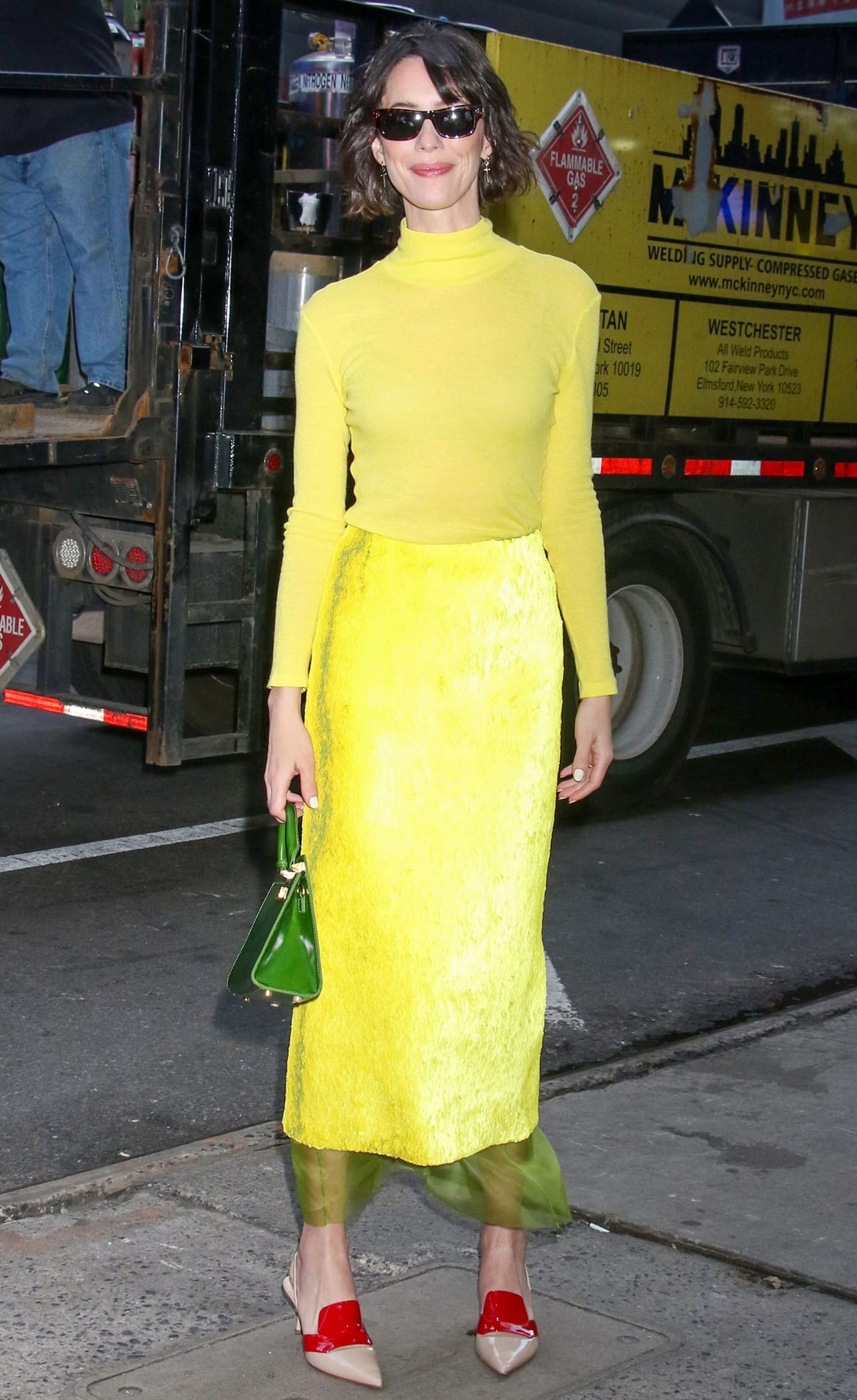 Rebecca Hall captures attention in a bright yellow ensemble by One Of paired with eye-catching Prada pumps in New York City