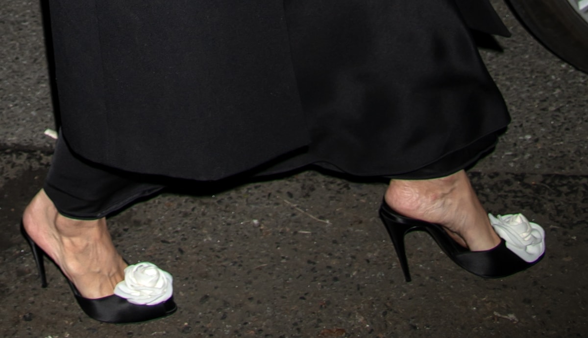 Demonstrating understated elegance, Katie Holmes pairs her simple yet sophisticated ensemble with $1,120 black suede Magda Butrym heels featuring a large cream camellia