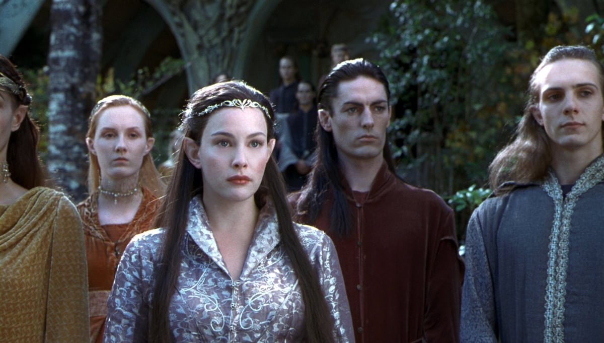 At just 22 at the start of filming, Liv Tyler embodies Arwen’s ethereal authority in The Lord of the Rings, her silver-embroidered gown, center-parted lengths, and delicate circlet creating a look that feels both otherworldly and quietly regal—an enduring blueprint for fantasy fashion elegance