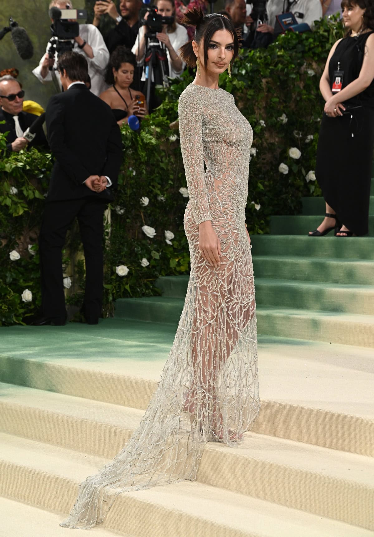 The intricate details of the vintage Atelier Versace gown shine as Emily ascends the Metropolitan Museum's grand staircase, with twig-like silver crystals and floral motifs adorning her silhouette