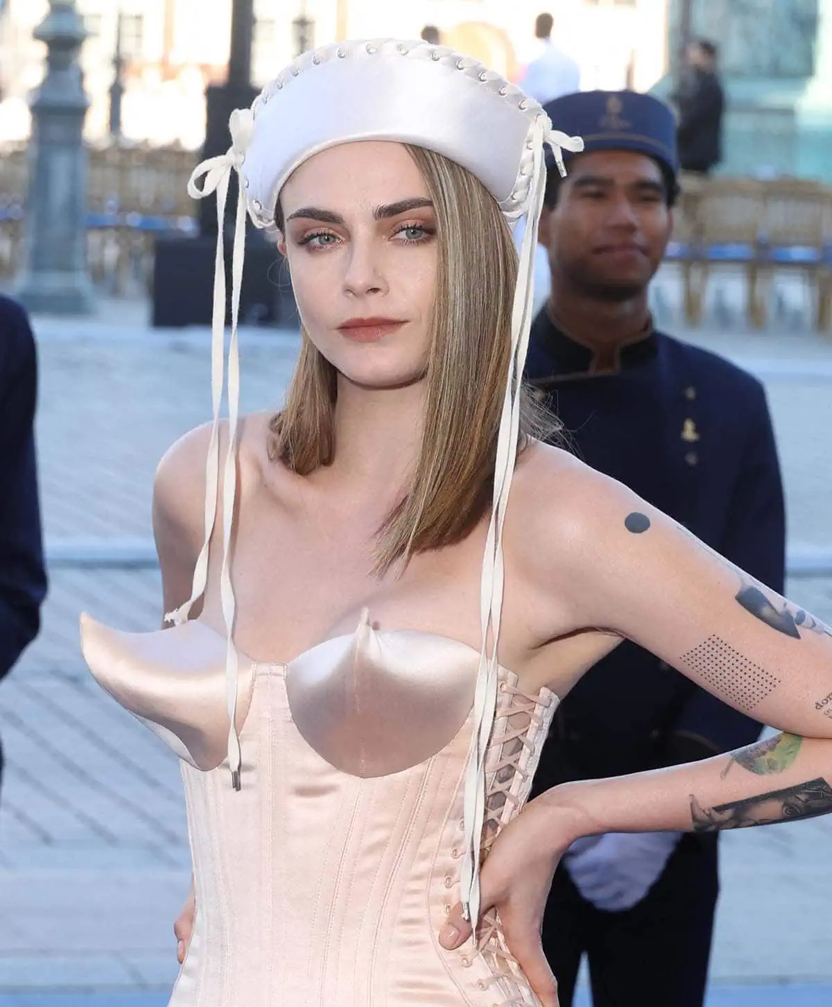 Cara Delevingne's corset mini-dress has a low-cut neckline with an upturned conical bra, revisiting Madonna's 1990 Blonde Ambition tour looks