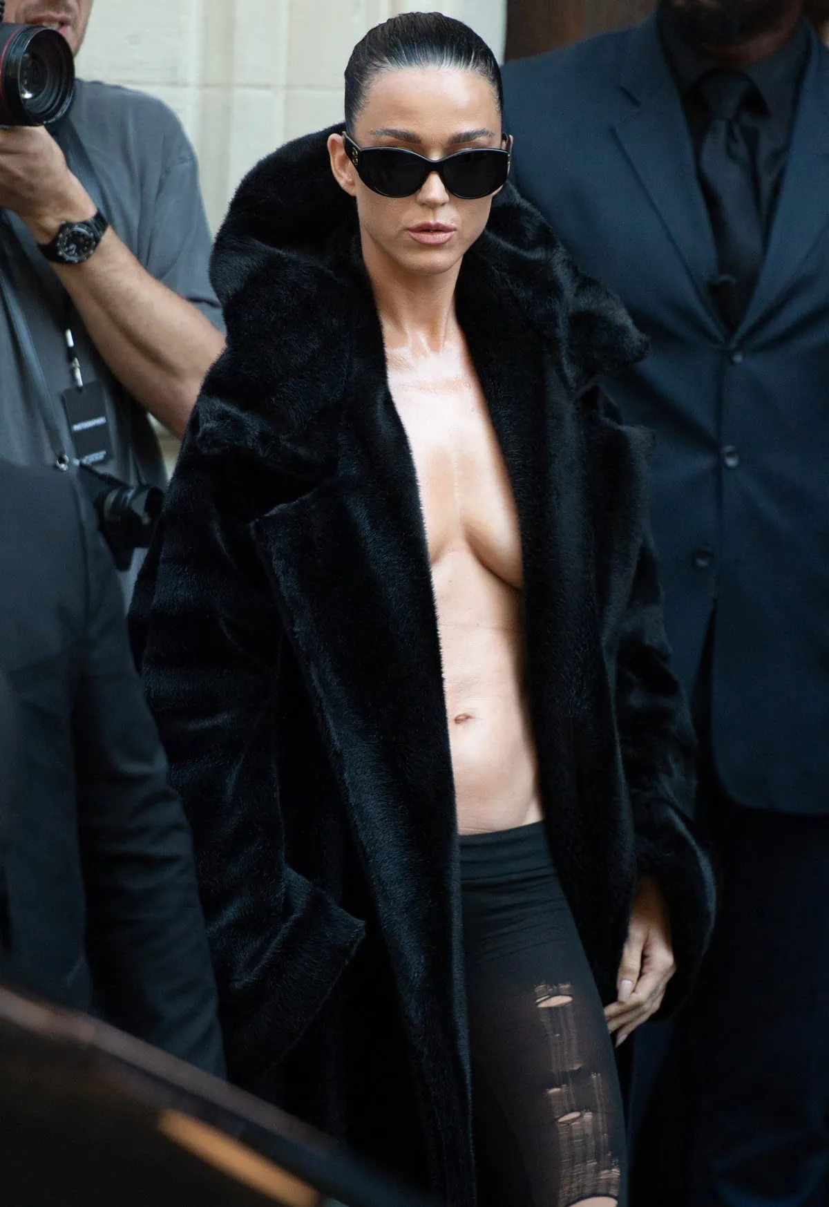 Katy Perry makes a bold statement at Paris Fashion Week in a black fur coat and sheer Balenciaga tights, paired with sleek sunglasses