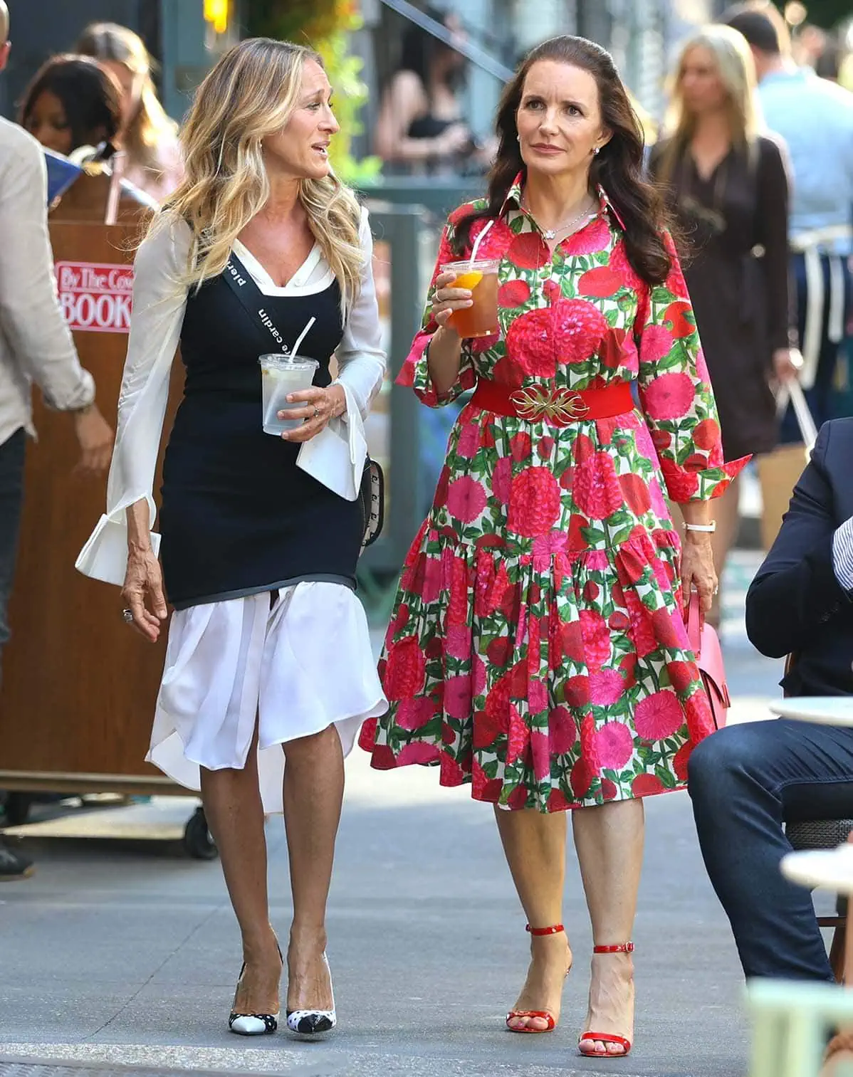 Sarah Jessica Parker wears black-and-white while filming a scene with Kristin Davis, who overshadows her in a pink-and-green floral dress