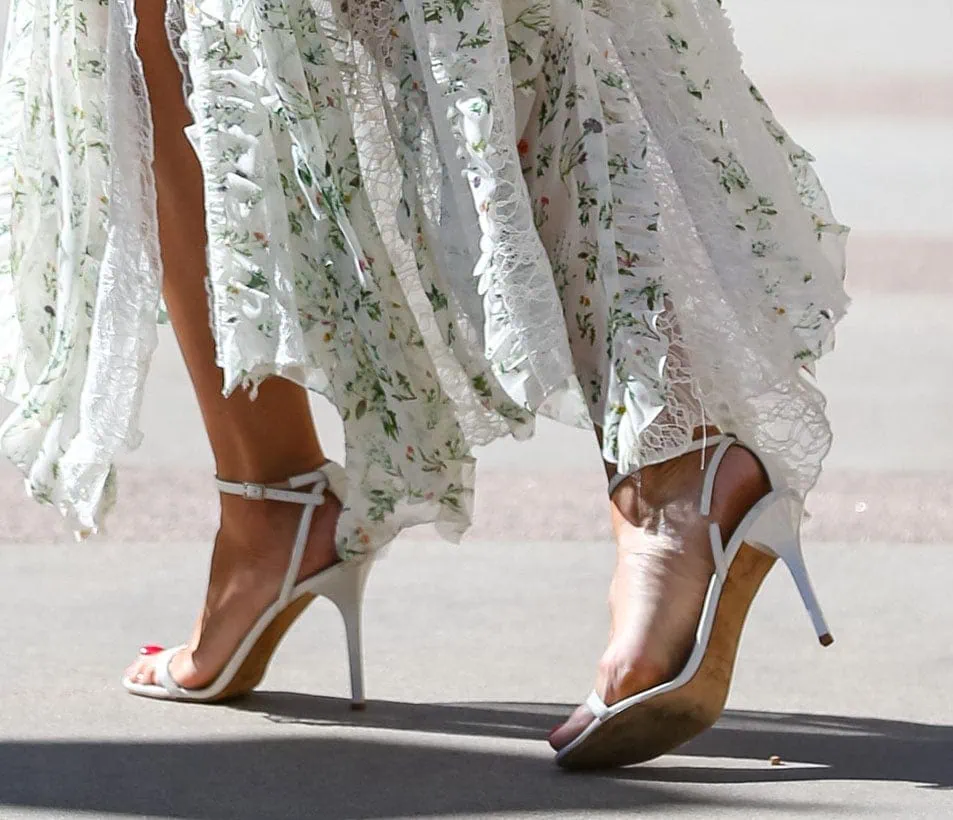 Heidi Klum completes her summertime look with white open-toe sandals, showcasing her red pedicure