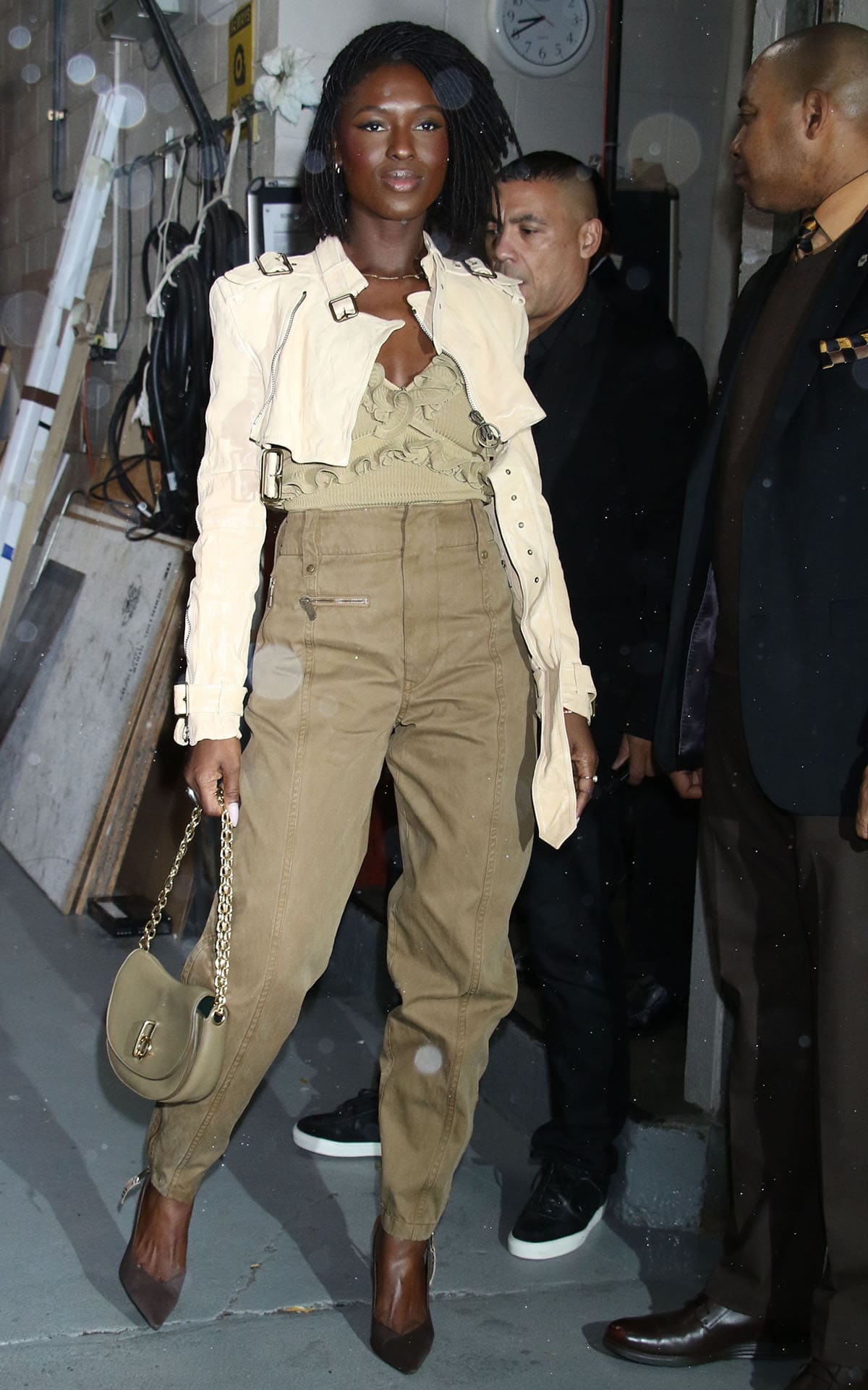 Jodie Turner-Smith visits Live with Kelly Mark in a monochromatic army green ensemble featuring a ribbed, ruffled top, tapered jeans, and an ivory cropped jacket