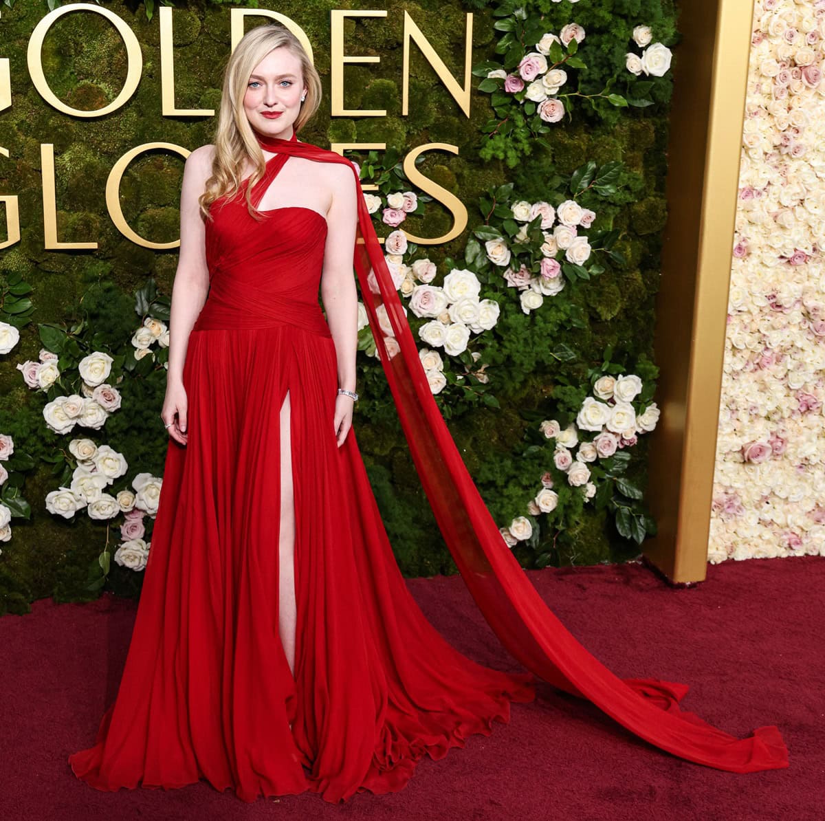 Dakota Fanning exuded elegance at the 2025 Golden Globe Awards in a striking Dolce Gabbana custom red gown with a flowing cape and thigh-high slit—though her choice of shoes remained hidden beneath the sweeping fabric