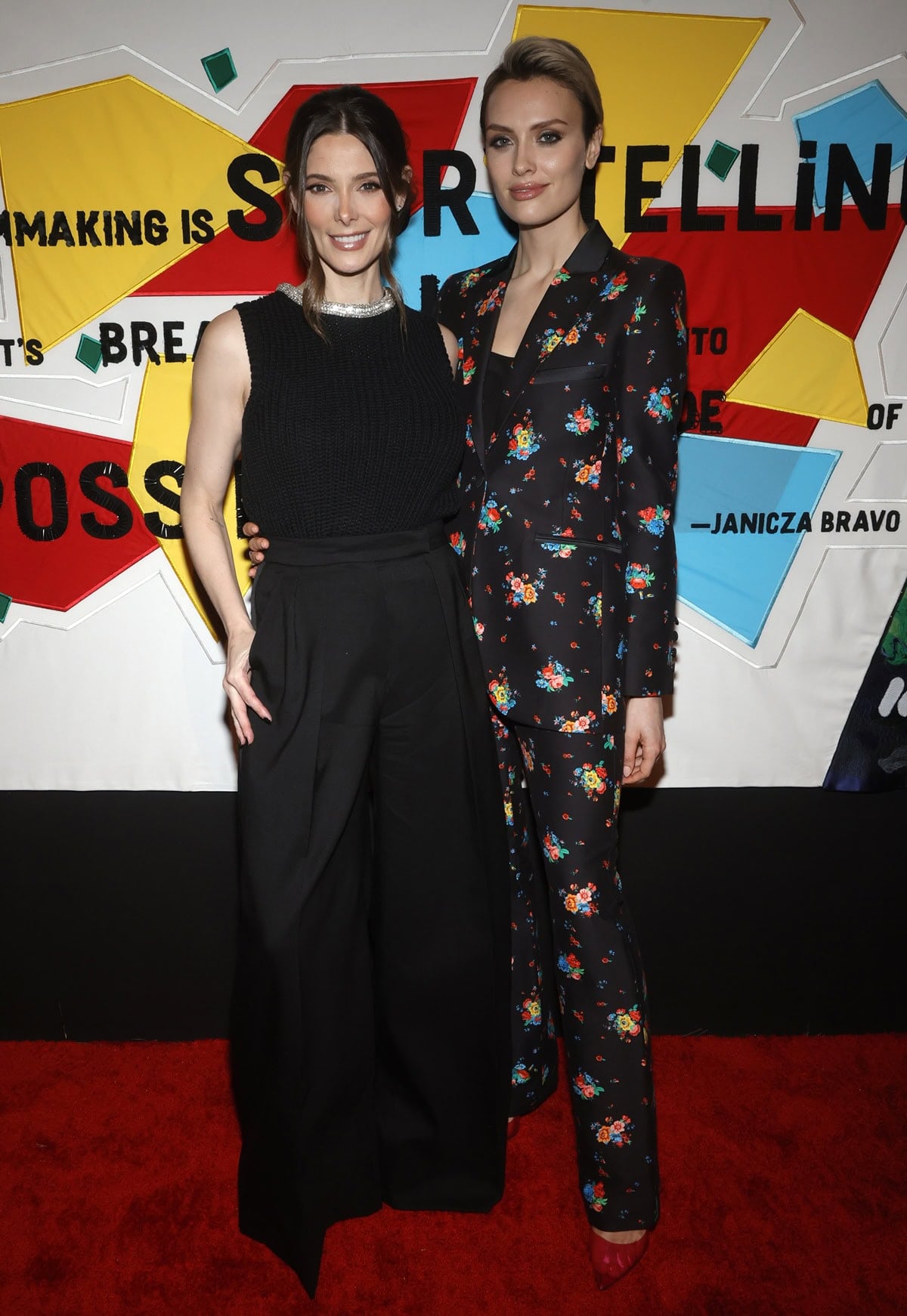 Ashley Greene looked chic in a sleeveless black knit top and wide-leg trousers, appearing noticeably shorter next to 5ft 8½ (174 cm) tall Wallis Day in a bold floral pantsuit at the 2023 WIF Oscar Party held at NeueHouse Los Angeles