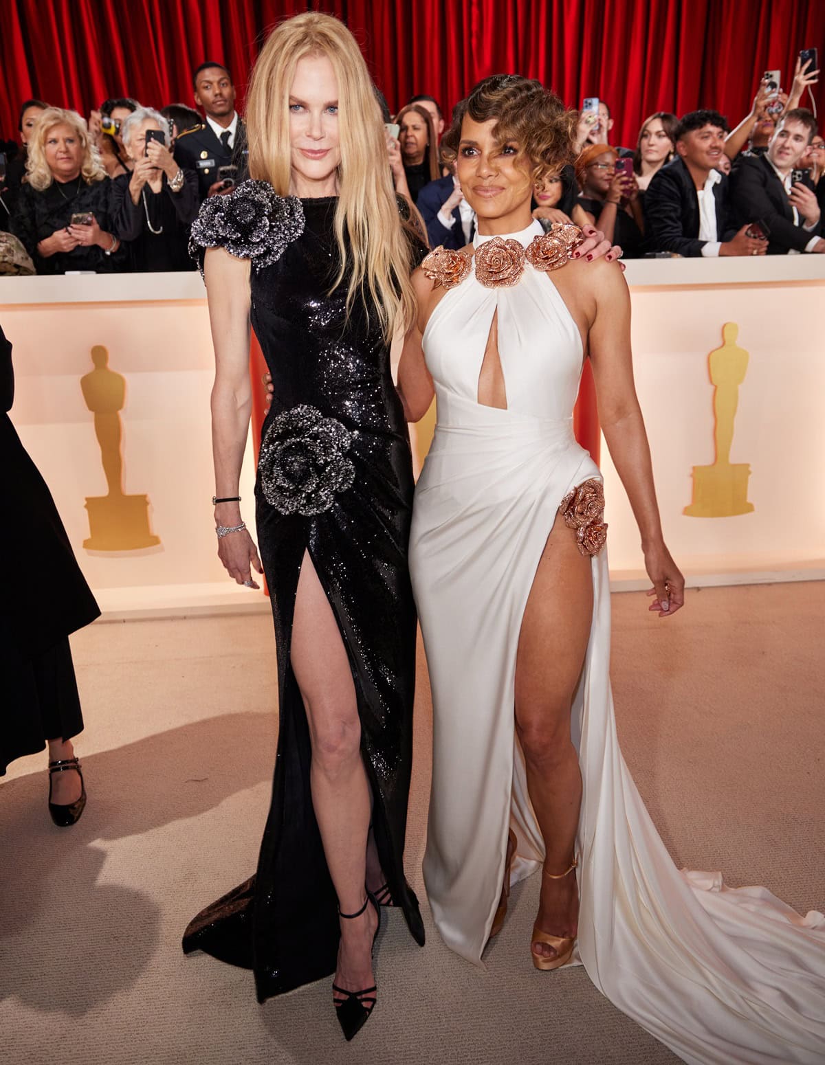 Halle Berry adds height in gold Jimmy Choo Max platform sandals and a white floral-appliquéd Tamara Ralph gown while posing beside 5'10½"-to-5'11" Nicole Kidman in a black sequined Giorgio Armani Privé gown at the 95th Academy Awards