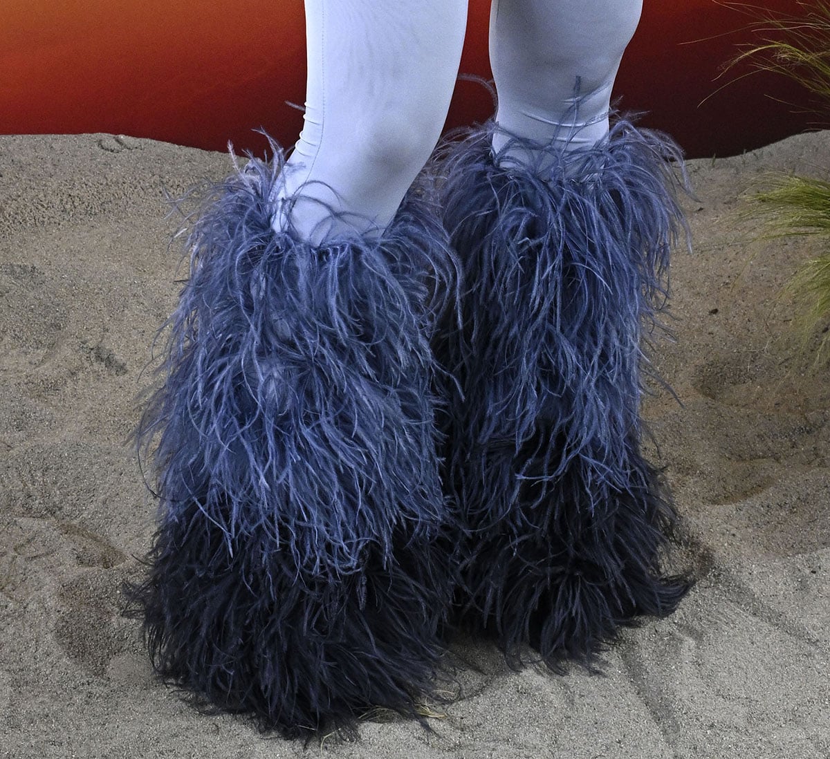 Cardi B looks striking in a pair of thick feather boots in ombre lilac and navy blue