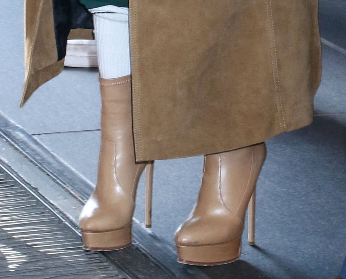 Cynthia Erivo lends polished sophistication to her green sweatsuit with a camel suede coat and nude leather Casadei ankle boots with platforms and stiletto heels