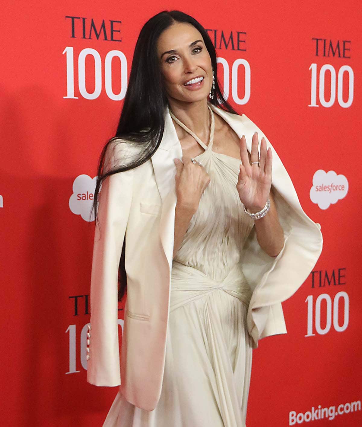 Demi Moore drapes a white tuxedo jacket by GapStudio over her shoulders, adding a hint of warmth and formality to the elegant dress