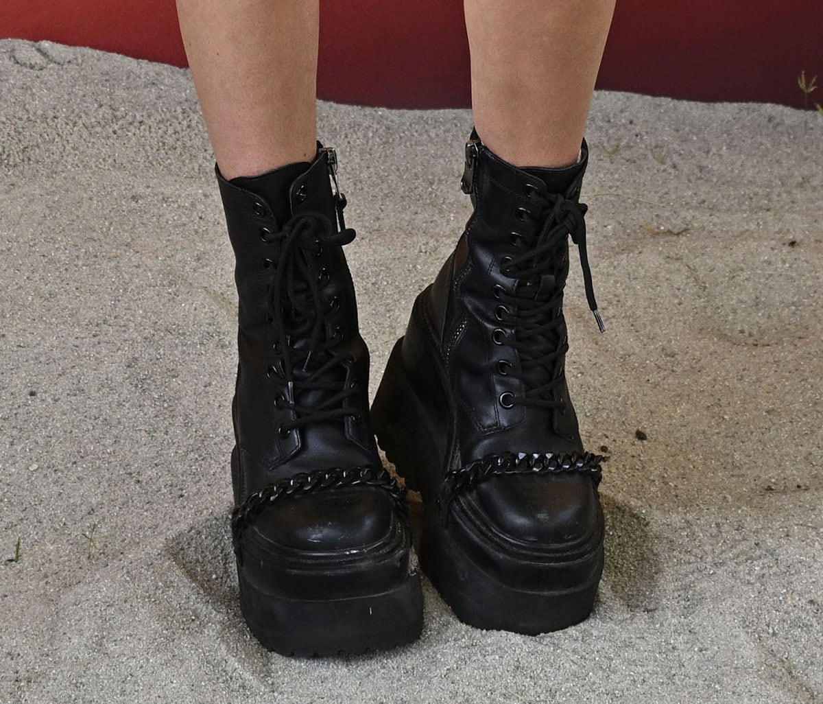 Dixie D'Amelio parades her legs in the Camdon platform boots with a permanent chain accent across the vamps from the D'Amelio Footwear collection
