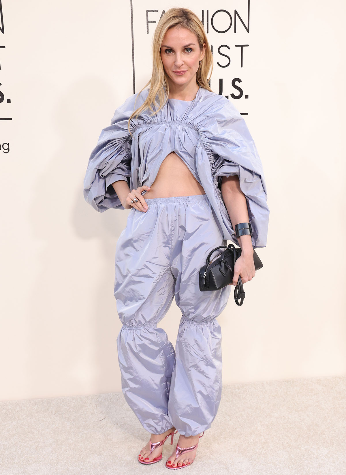 Gaia Repossi complements her pink sandals with a two-piece lavender taffeta outfit from Alaia featuring ruching and elastic details