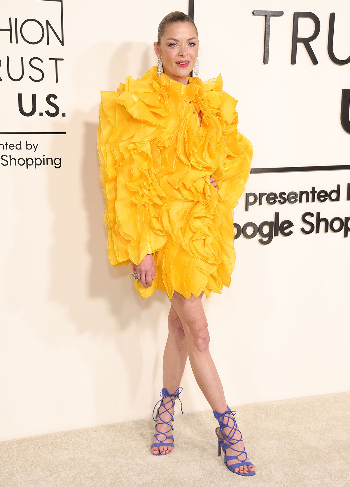 Jaime King looks vibrant and summery, teaming her bold sandals with a yellow organza mini-dress by Jovana Louis