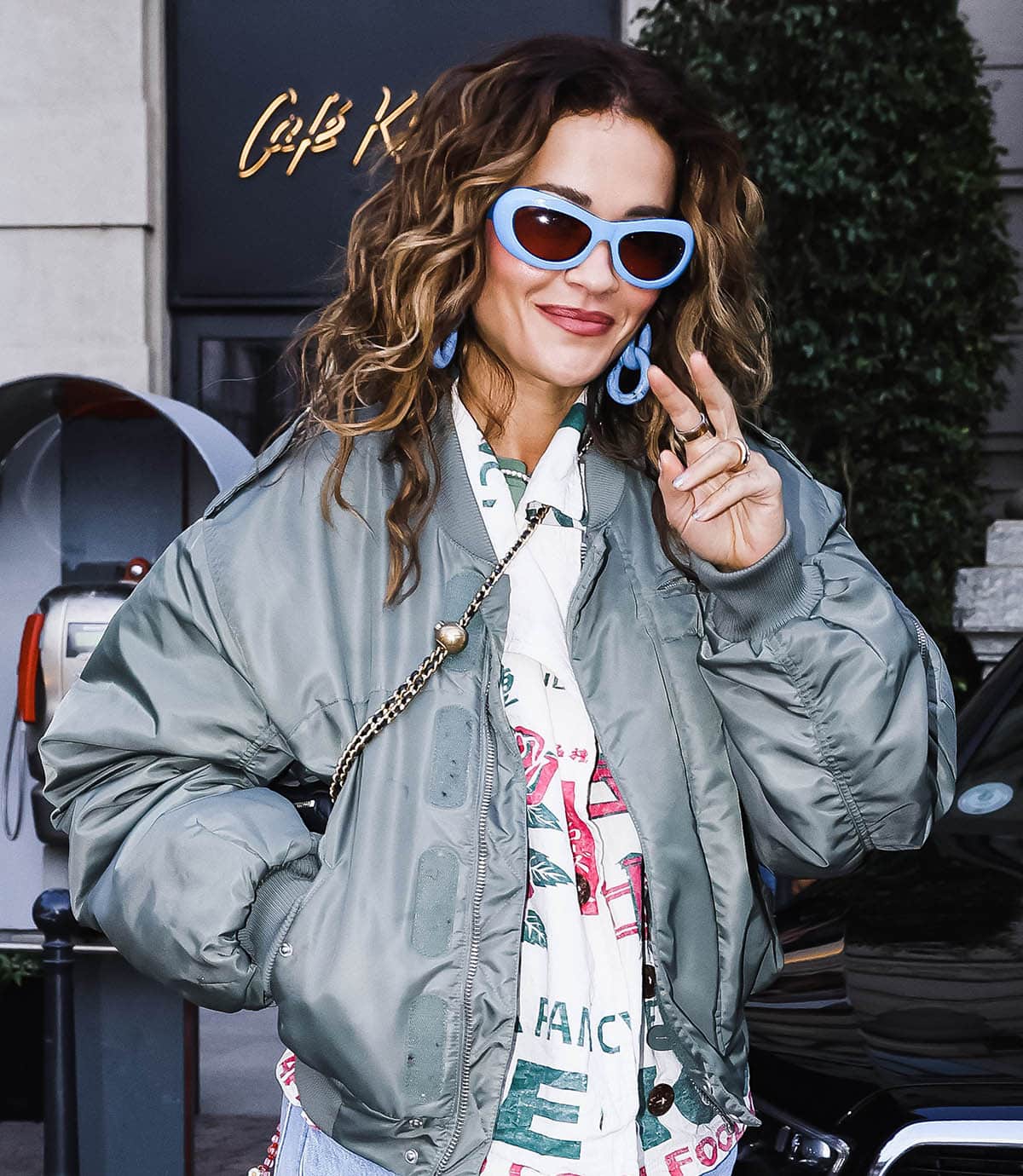 Rita Ora adds even more color to her look with blue-framed Marni sunglasses and chunky blue chain earrings