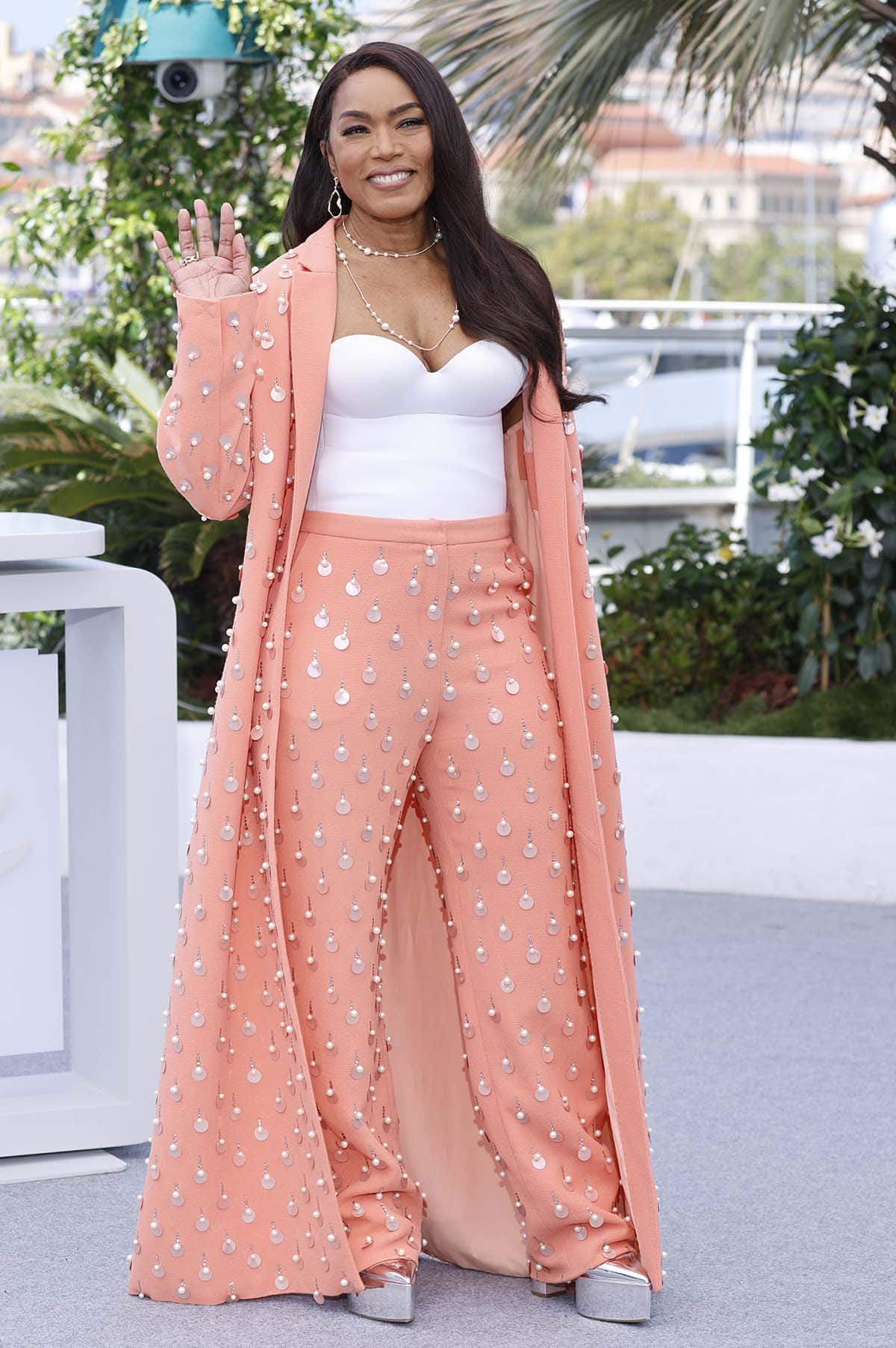 Angela Bassett looks spring-ready in a white bustier top and peachy salmon co-ords adorned with paillettes, pearls, and crystals at the Mission: Impossible – The Final Reckoning Cannes photocall