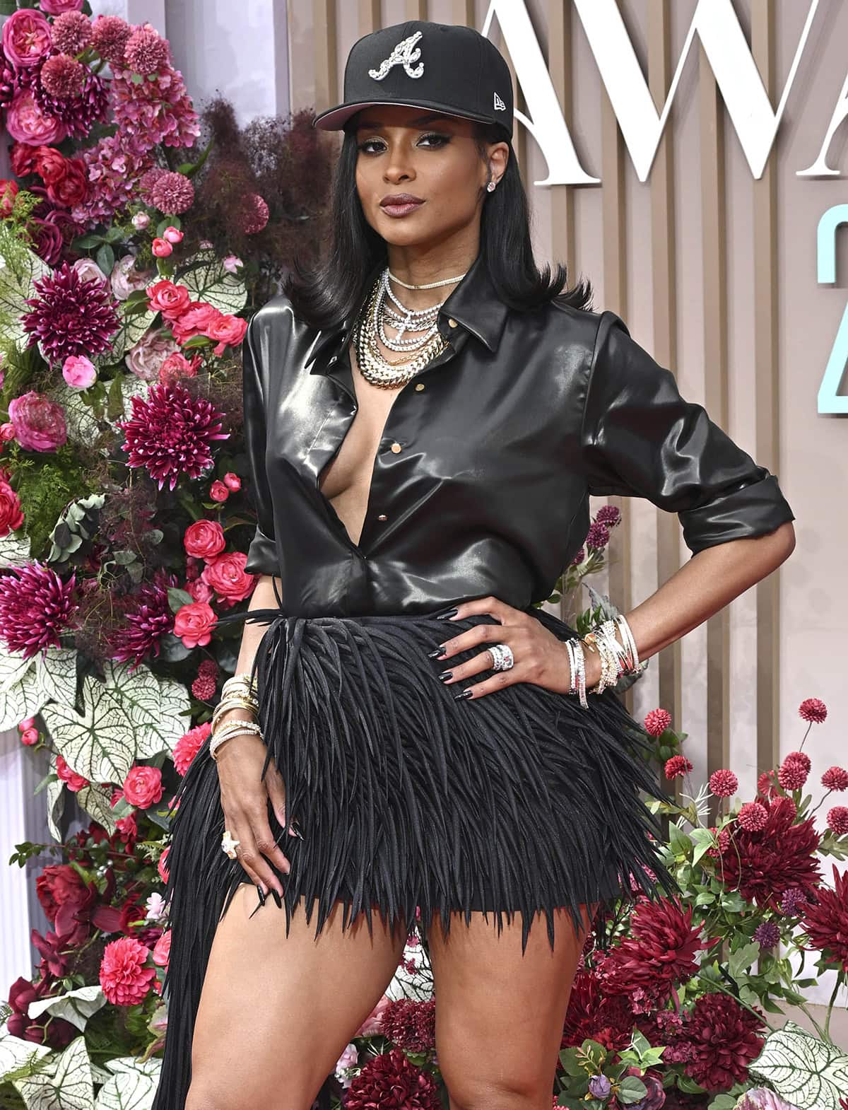 Ciara wows in a Cong Tri ensemble comprised of a black lacquer silk shirt and a fringed mini skirt with a long fringed train