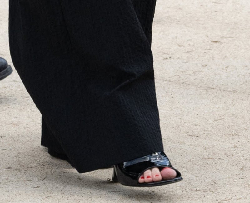 Kirsten Dunst completes her ensemble with black patent open-toe mule sandals, showcasing her red pedicure