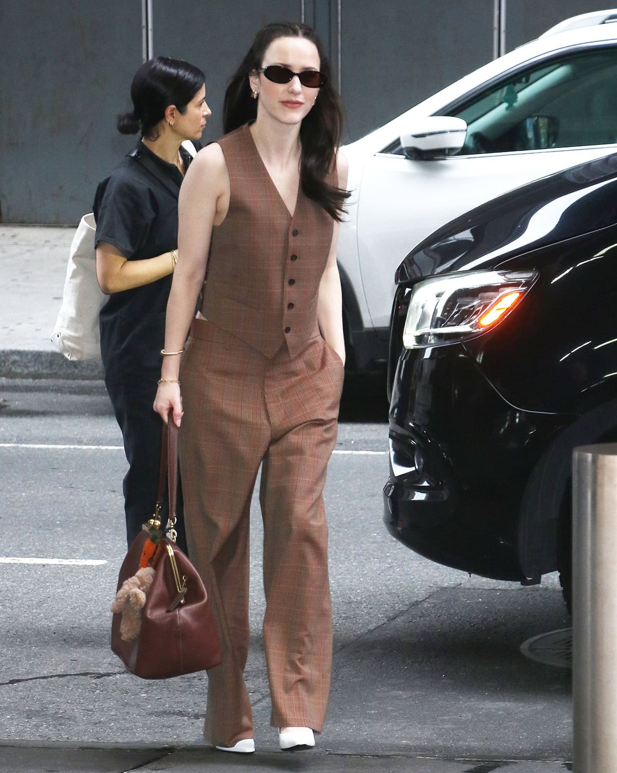 Rachel Brosnahan embraces retro sophistication in a brown plaid vest and matching pants from Coach's Fall 2025 collection outside CBS Mornings