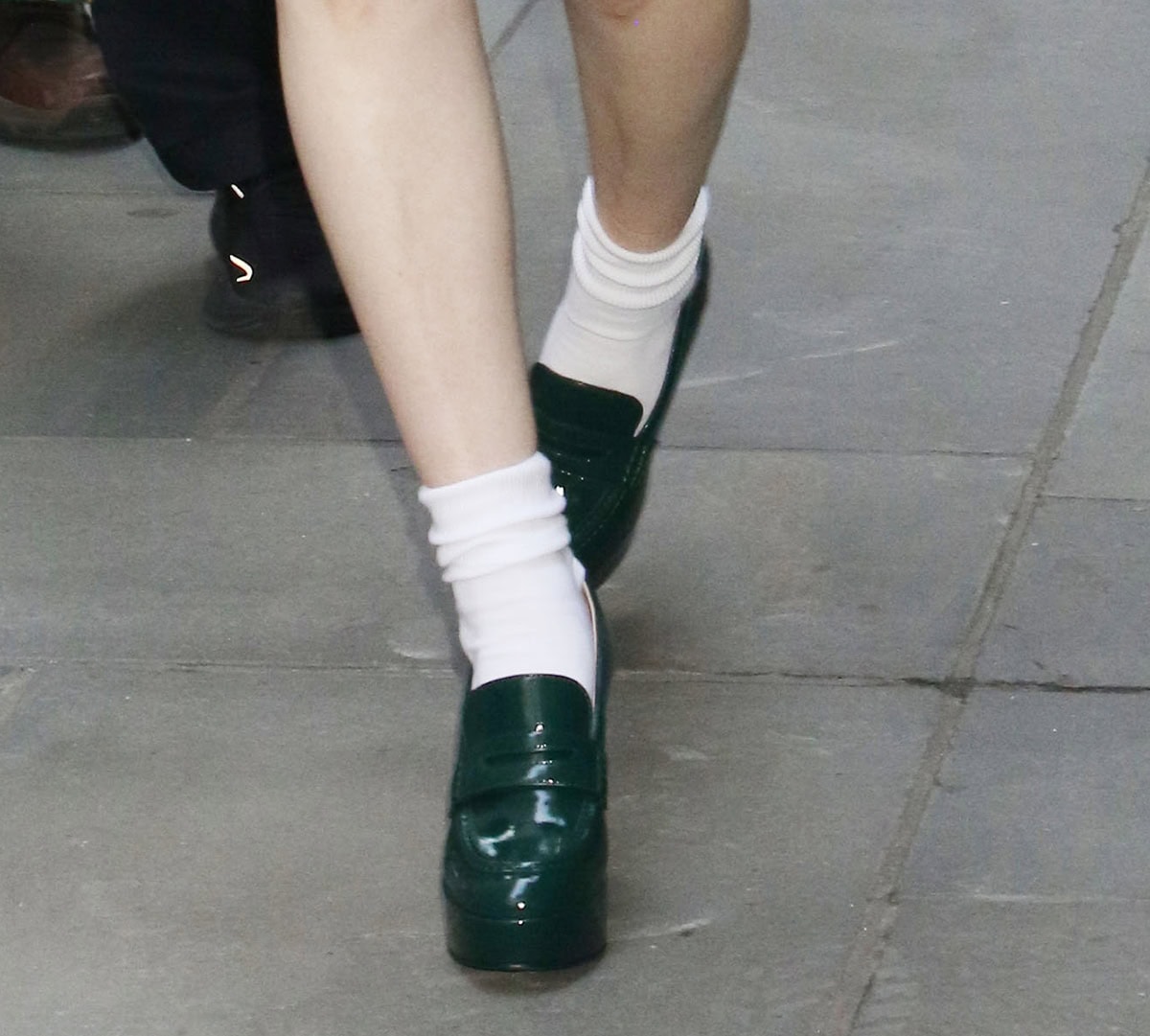 Rachel Brosnahan keeps her look cohesive by pairing her green dress with white crew socks and green platform loafers