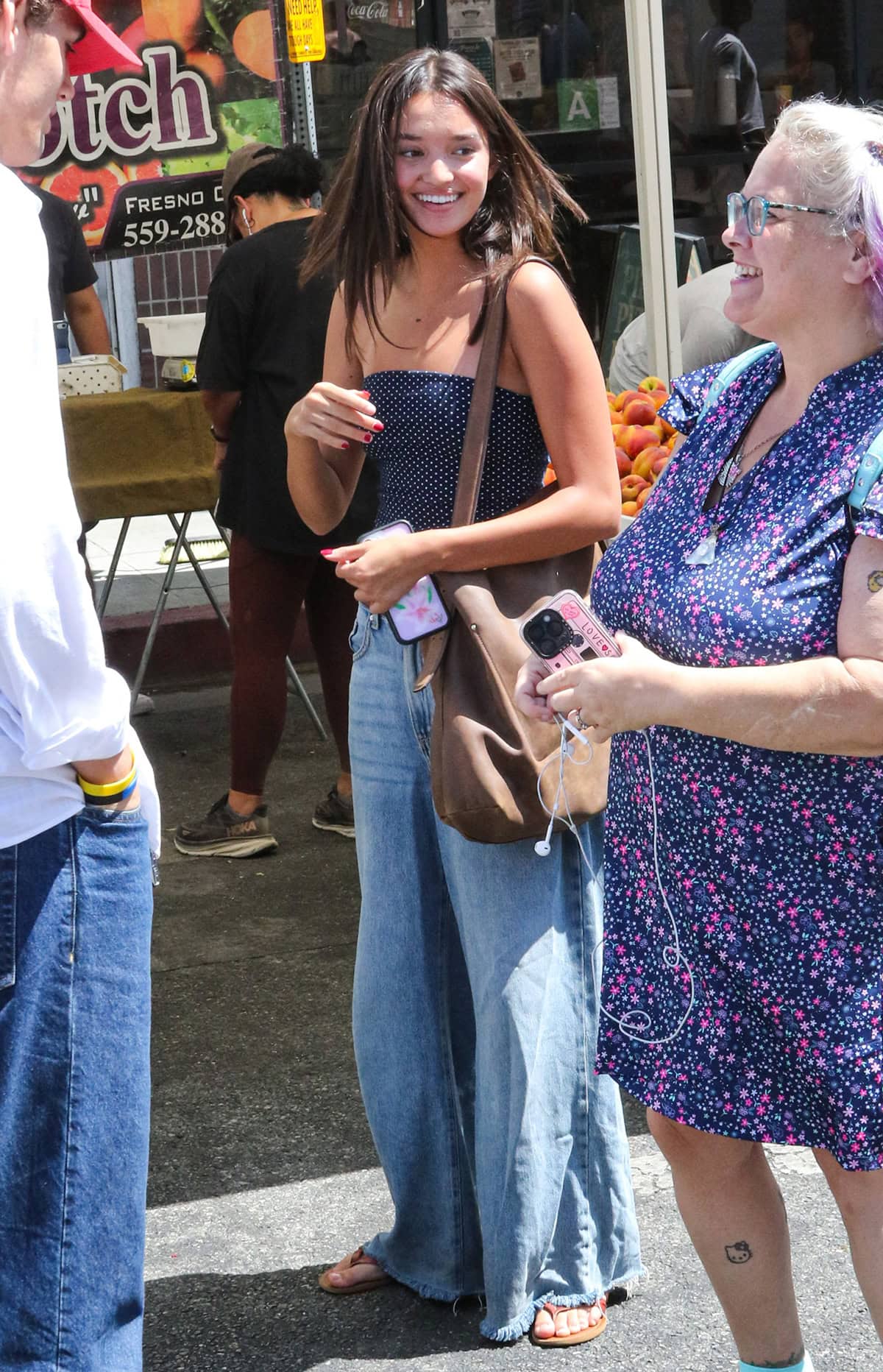 Sophia Hammons embraces Y2K street style in a navy polka dot crop top and baggy jeans with frayed hems
