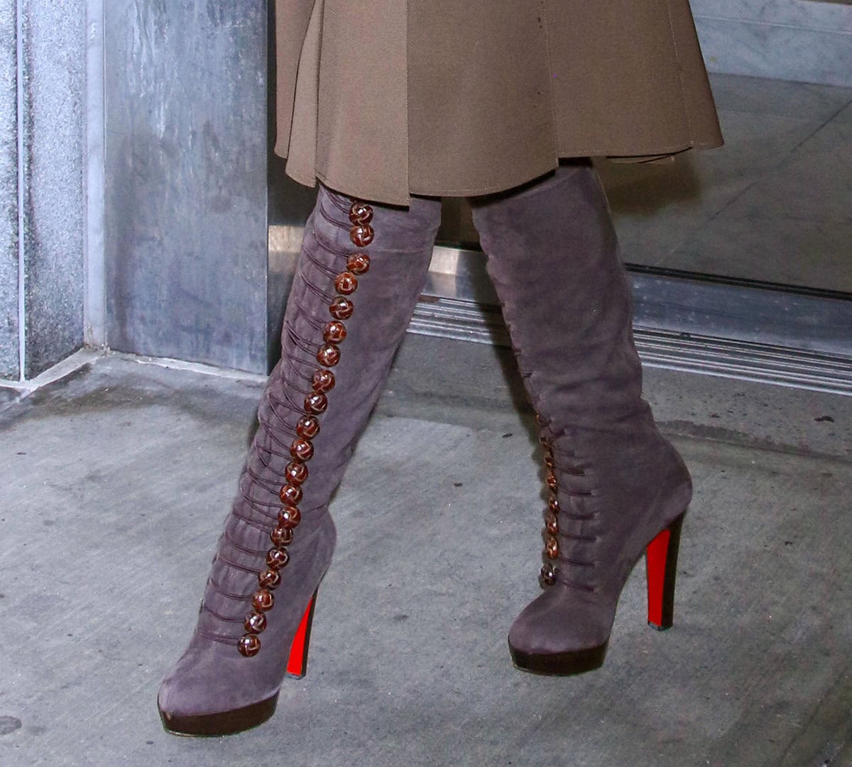 Blake Lively completes her autumn-ready brown ensemble with dark gray suede knee-high boots with bold side buttons by Christian Louboutin