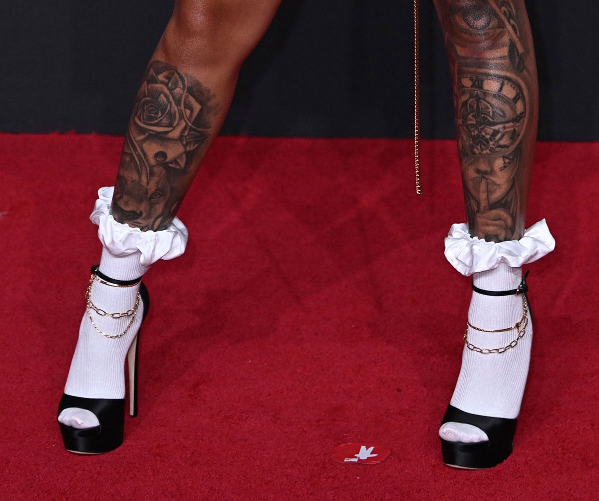 GloRilla puts a playful spin on a schoolgirl uniform with black satin peep-toe platform sandals with gold-tone anklet and ribbed white socks with ruffled cuffs
