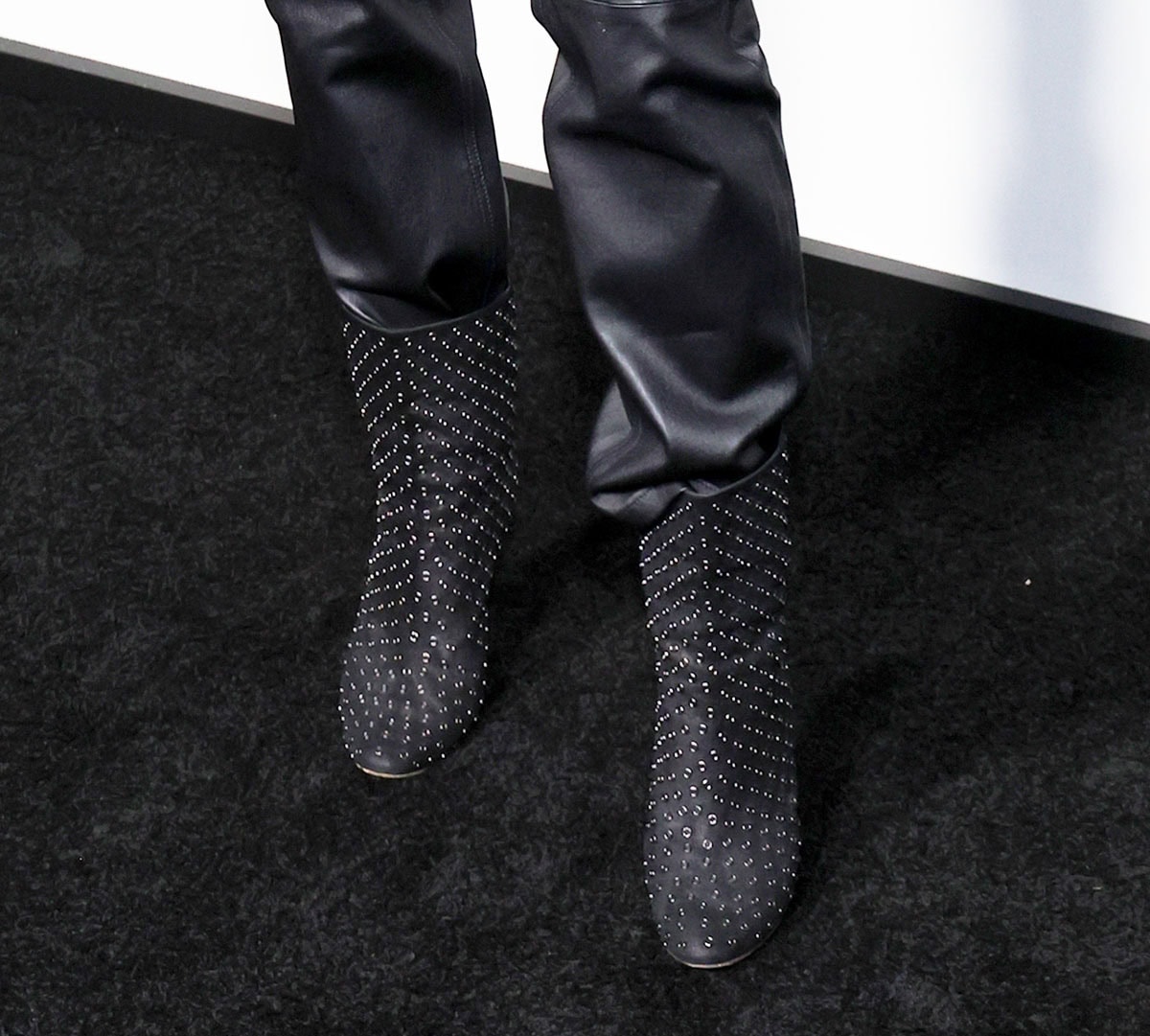 Kristen Wiig adds a tough-chic element to her sophisticated suit with studded black leather ankle boots