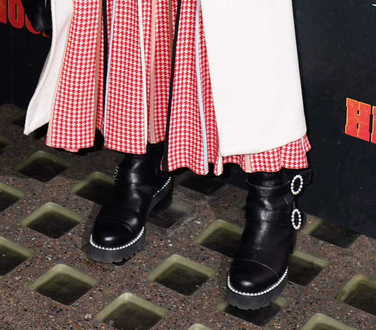 Dame Helen Mirren looks cool wearing a pair of Russell Bromley “Pearlqueen” biker boots featuring round pearl buckles and pearl trims