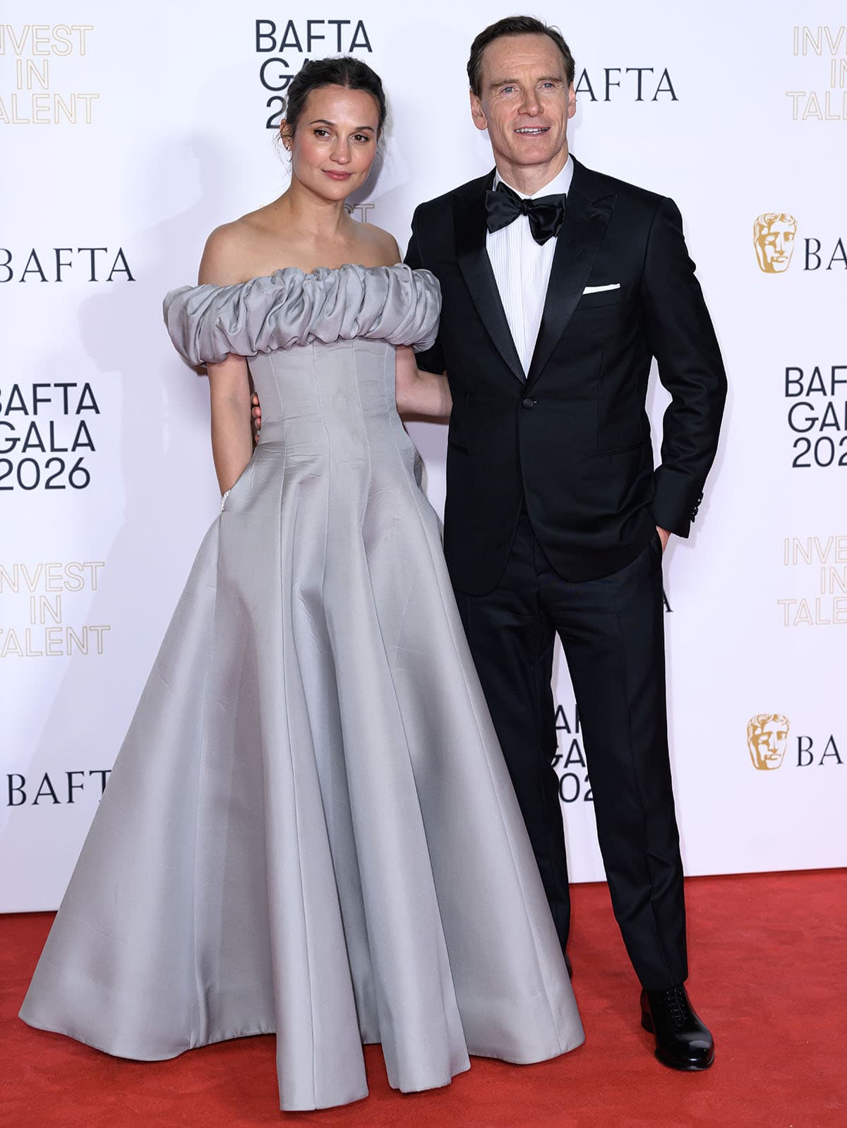 Alicia Vikander, with husband Michael Fassbender, channels her inner royal in a custom gray Louis Vuitton gown with a ruffled neckline and a voluminous full skirt