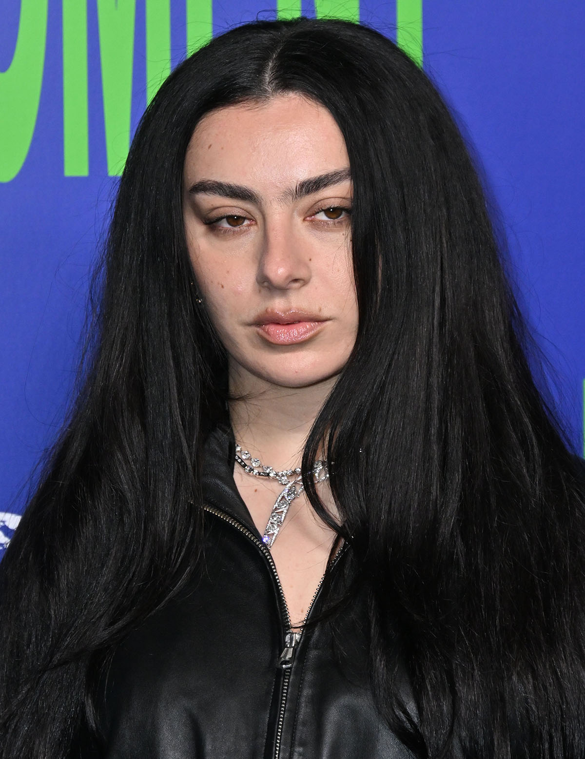 Charli XCX keeps her beauty understated with minimal makeup and an effortless hairstyle, and accessorizes with necklaces by Boodles