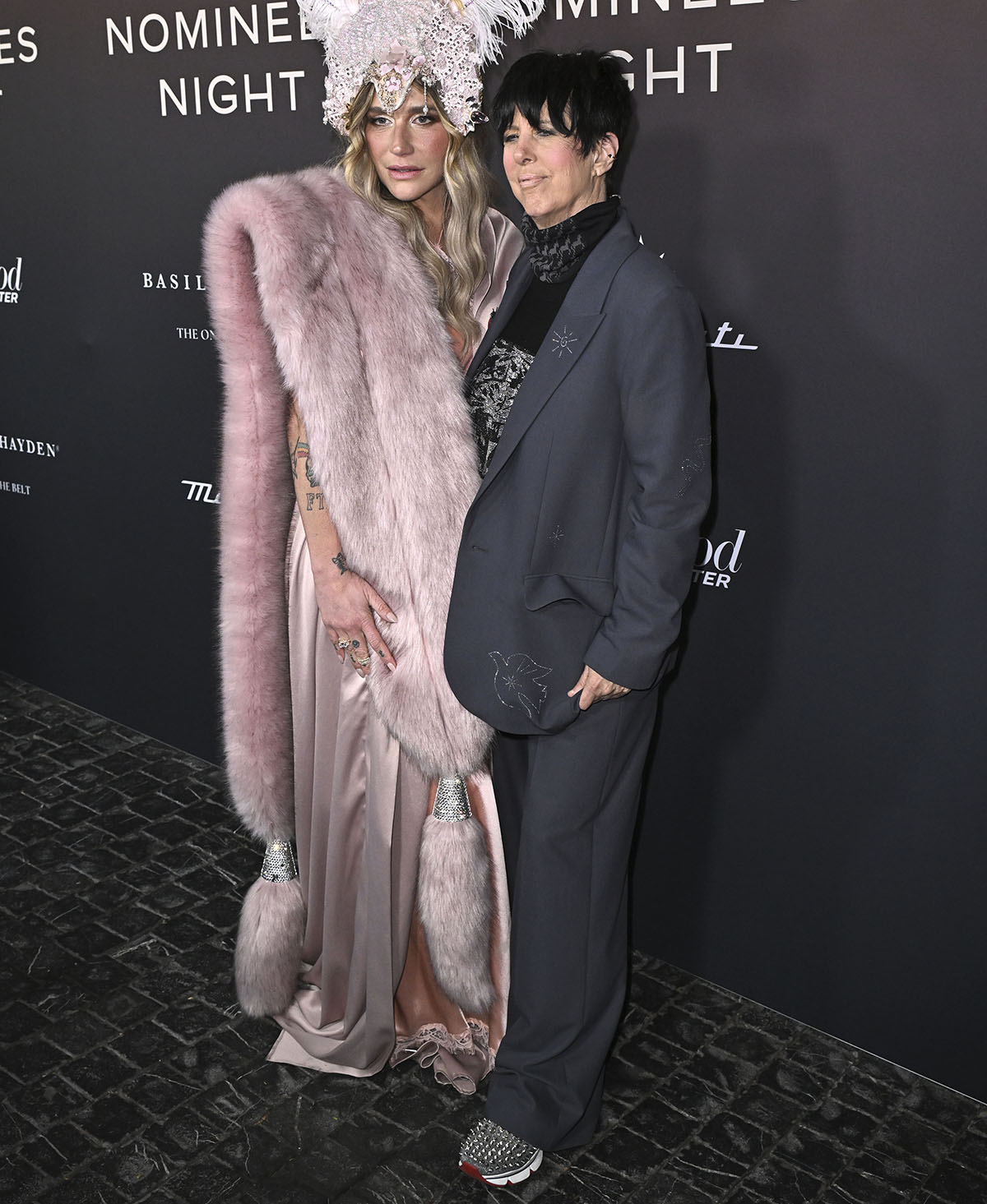 Diane Warren embraces her signature androgynous style in a gray Zadig Voltaire suit with playful rhinestone embellishments in the shapes of a bird, star, sun, waves, and a tree