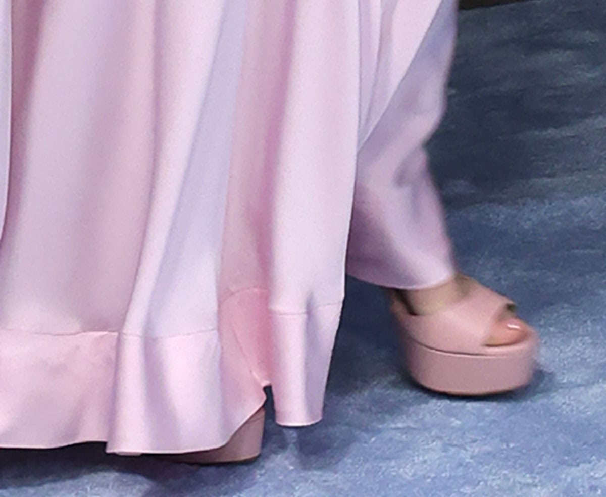 Dove Cameron slips into the nude-pink Jimmy Choo “Liberty” sandals with thick platforms and towering block heels