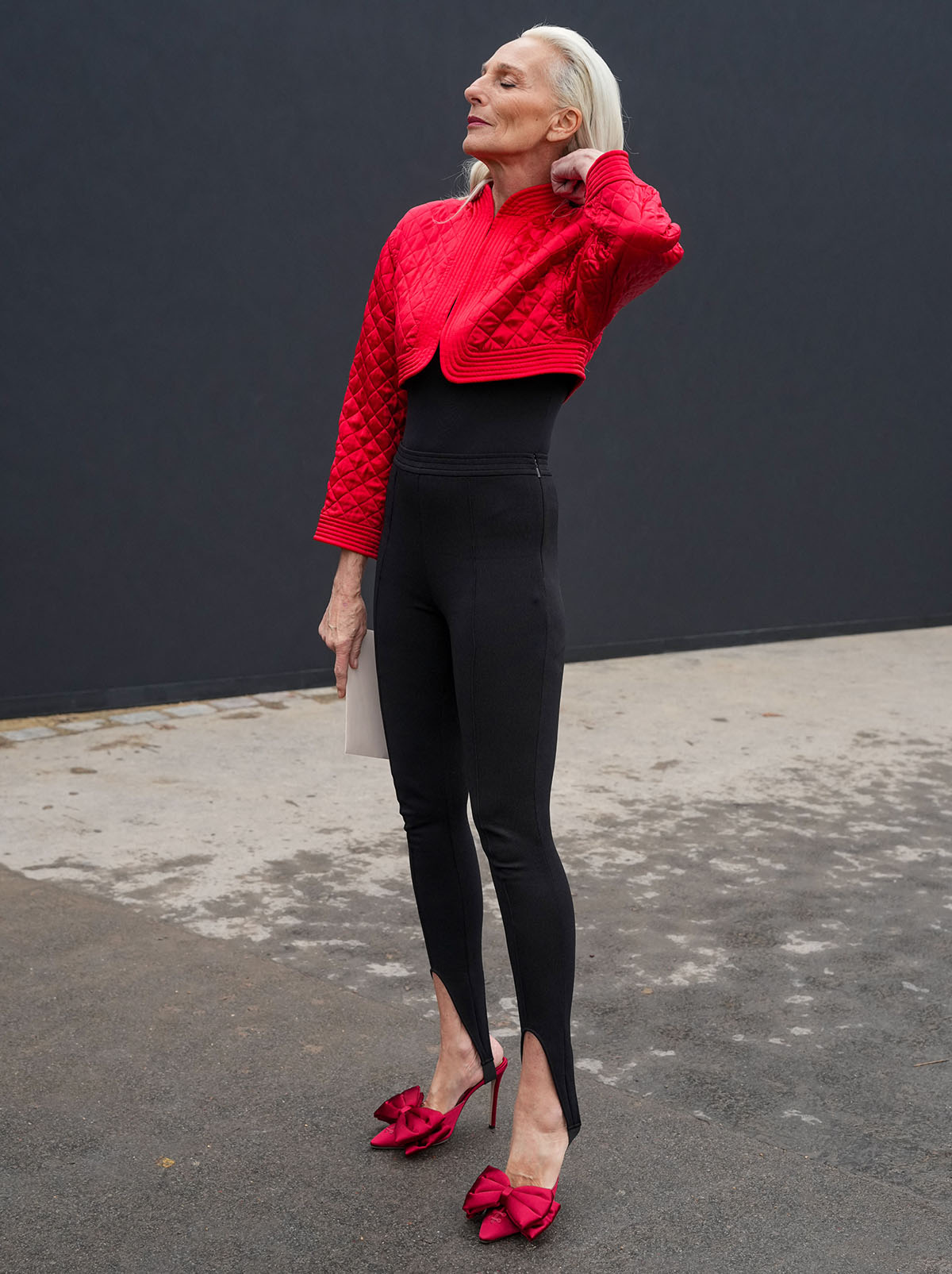 Elisabetta Dessy teams her red mules with black stirrup leggings, a fitted black top, and a red quilted cropped bolero