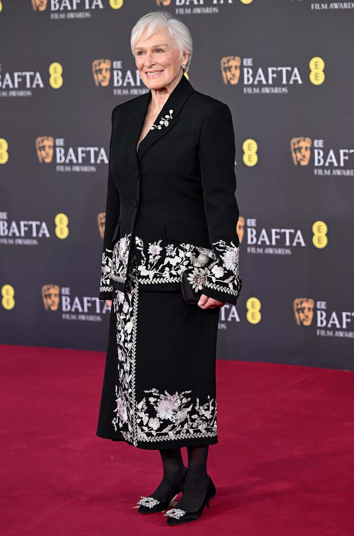 Glenn Close teams her crystal pumps with a black Erdem suit with silver floral embroidery at the cuffs and hems