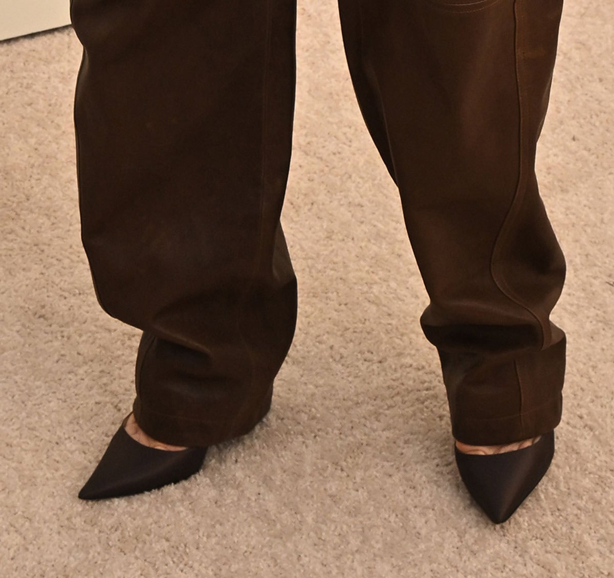Jessica Biel slips into a pair of pointed-toe brown pumps, matching her brown ensemble